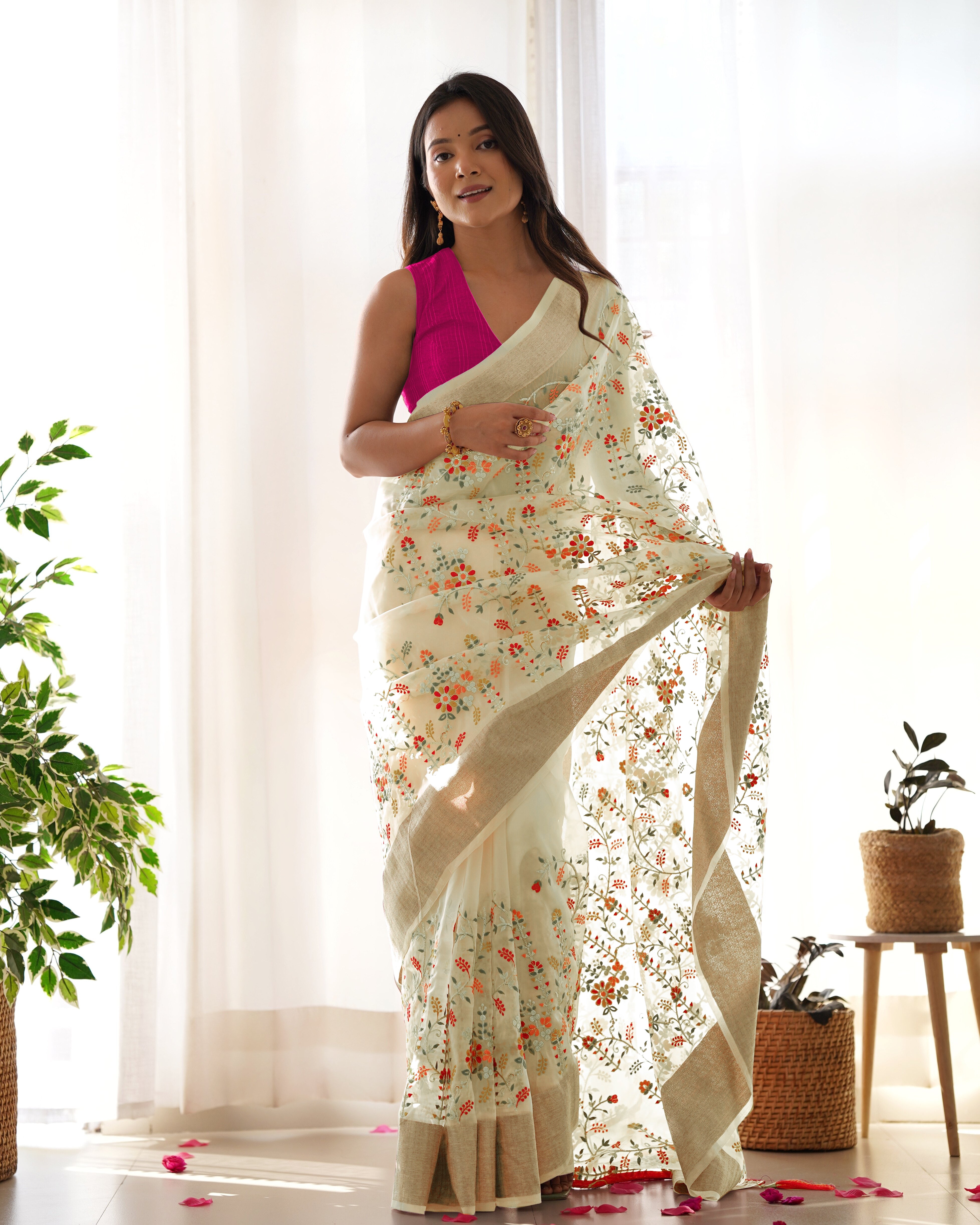 Cream pure organza silk saree with multicolor floral embroidery and solid pink blouse worn by a model