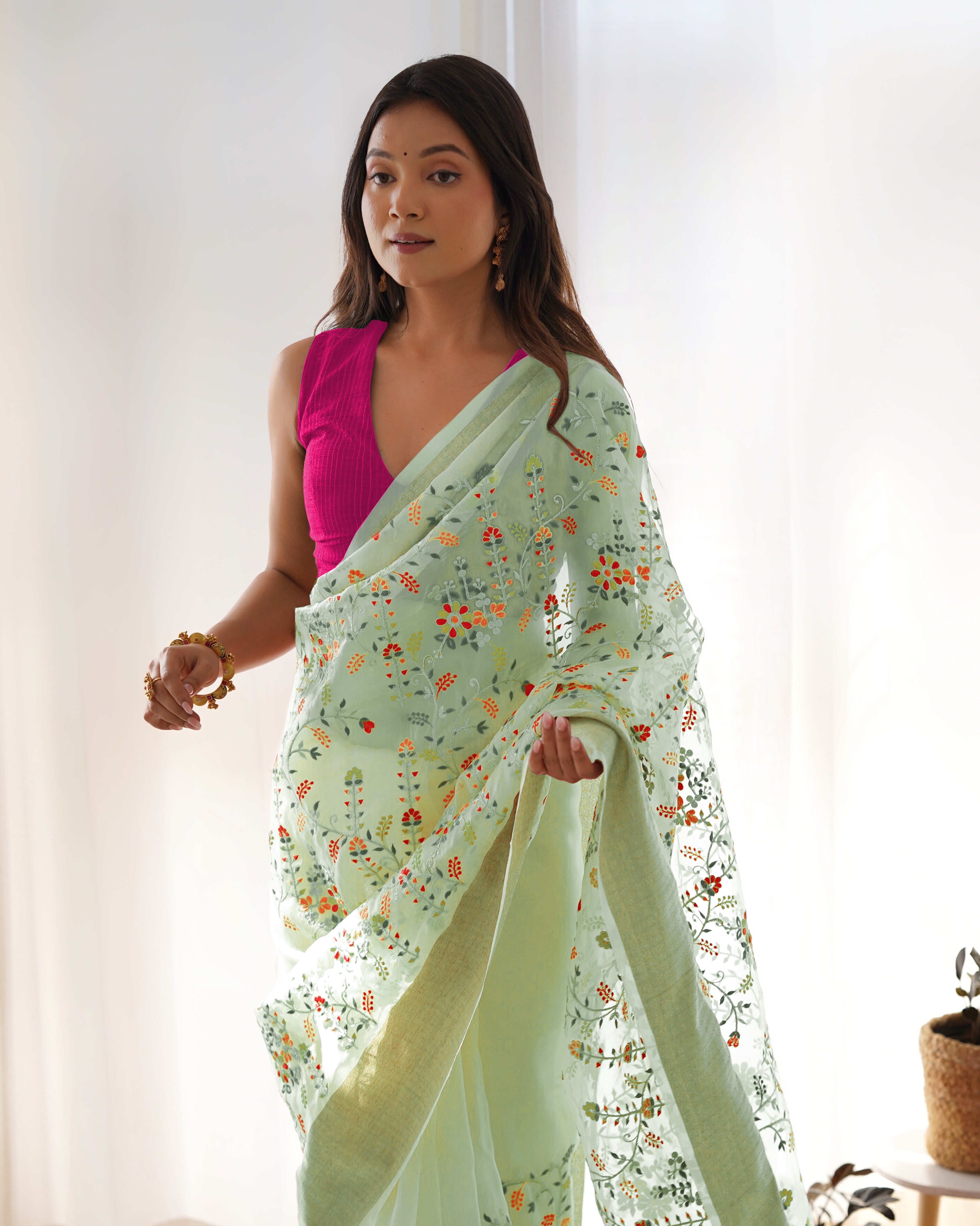 Cream pure organza silk saree with multicolor floral embroidery and solid pink blouse worn by a model