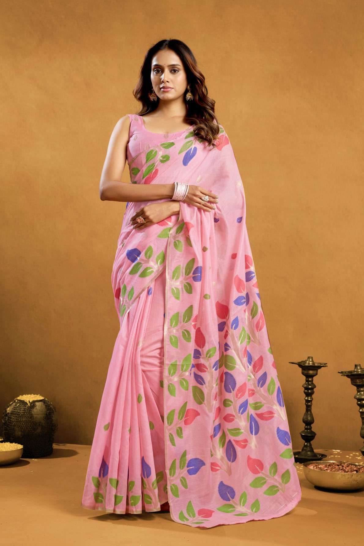 A Pure Cotton Spun Saree featuring exquisite all-over floral Jamdani weaving. The saree is accompanied by a running blouse piece detailed with all-over leaf weave butties and a matching border, available as a six-piece set.