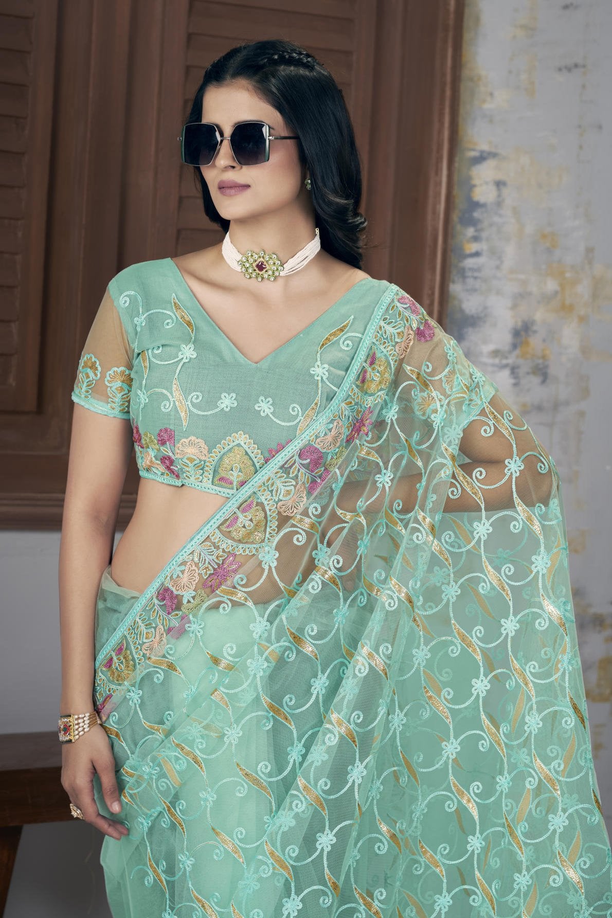 Model wearing Firozi heavy butterfly net saree with Aari Dori and foil thread embroidery suitable for weddings
