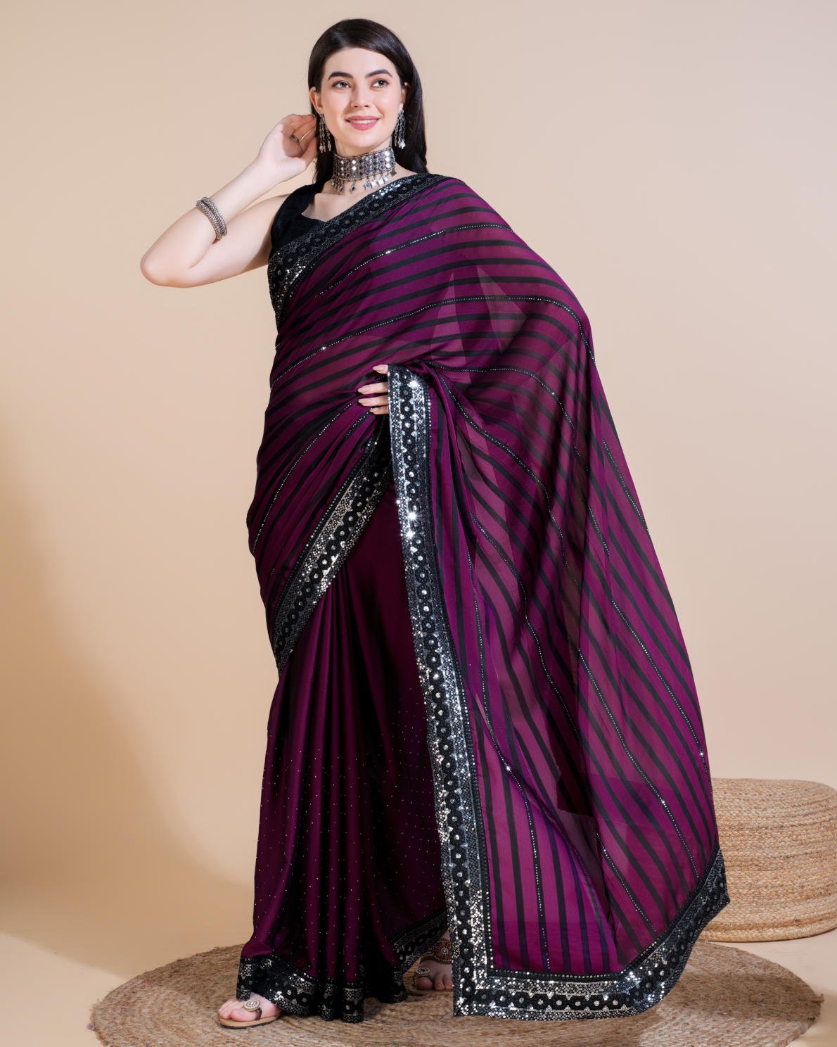Model wearing Rangoli Silk Leheriya saree with black stripes, hotfix work, and sequin embroidered border