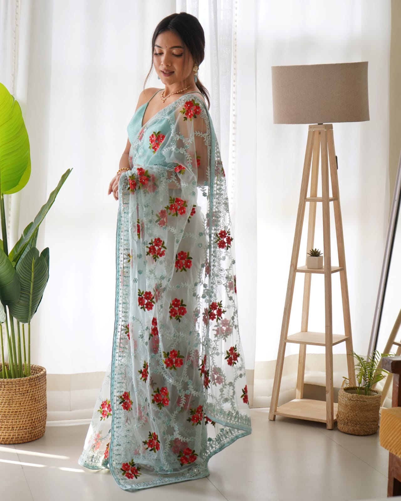 Mustard yellow heavy butterfly net saree with red and green floral aari embroidery and stone work