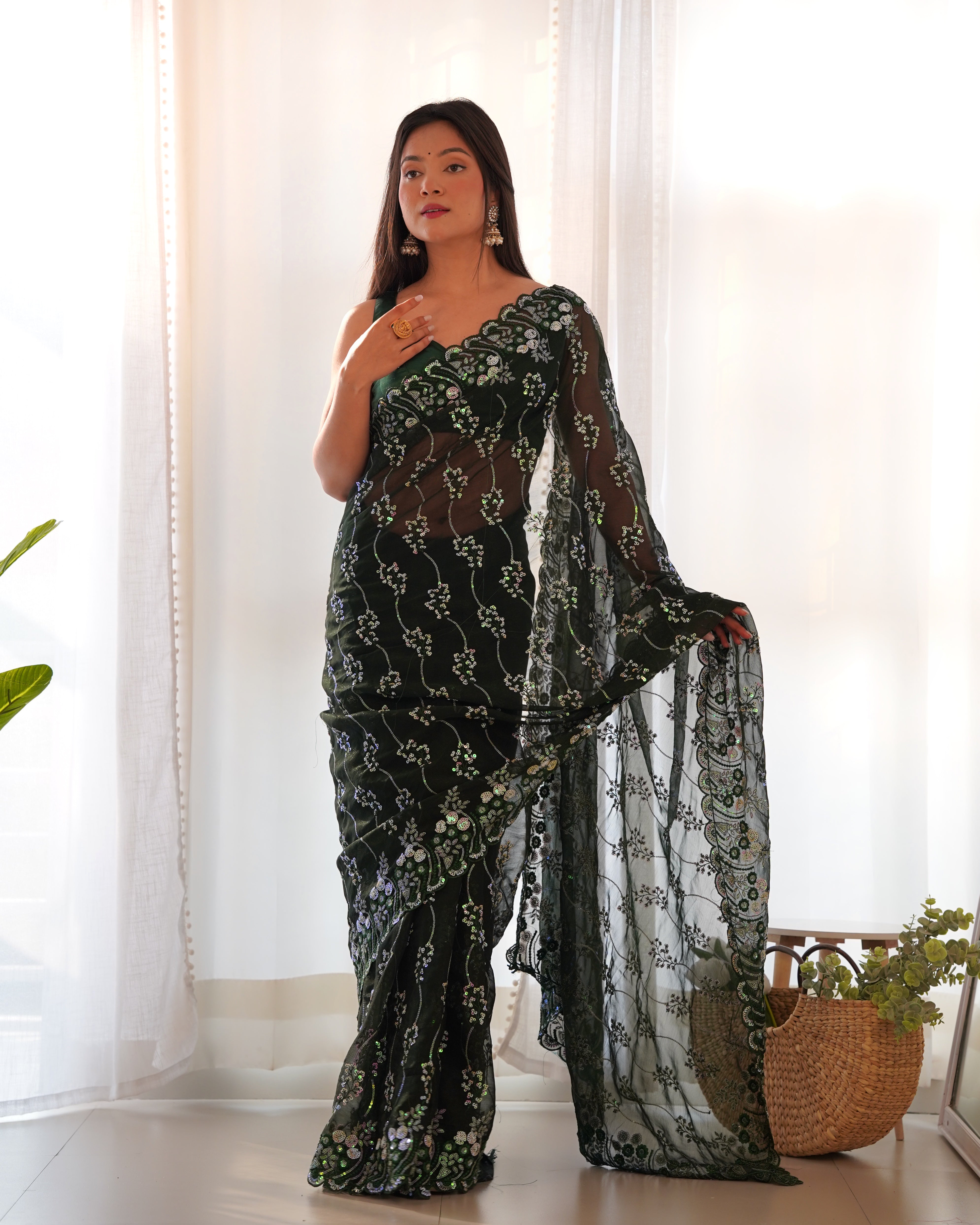 Model wearing a dark shimmer blooming saree with heavy 3mm and 5mm sequin embroidery and scalloped borders