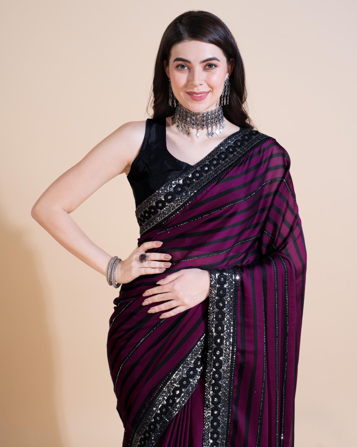 Model wearing Rangoli Silk Leheriya saree with black stripes, hotfix work, and sequin embroidered border