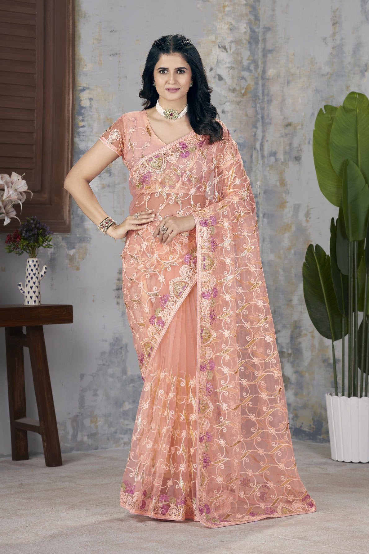Model wearing Firozi heavy butterfly net saree with Aari Dori and foil thread embroidery suitable for weddings