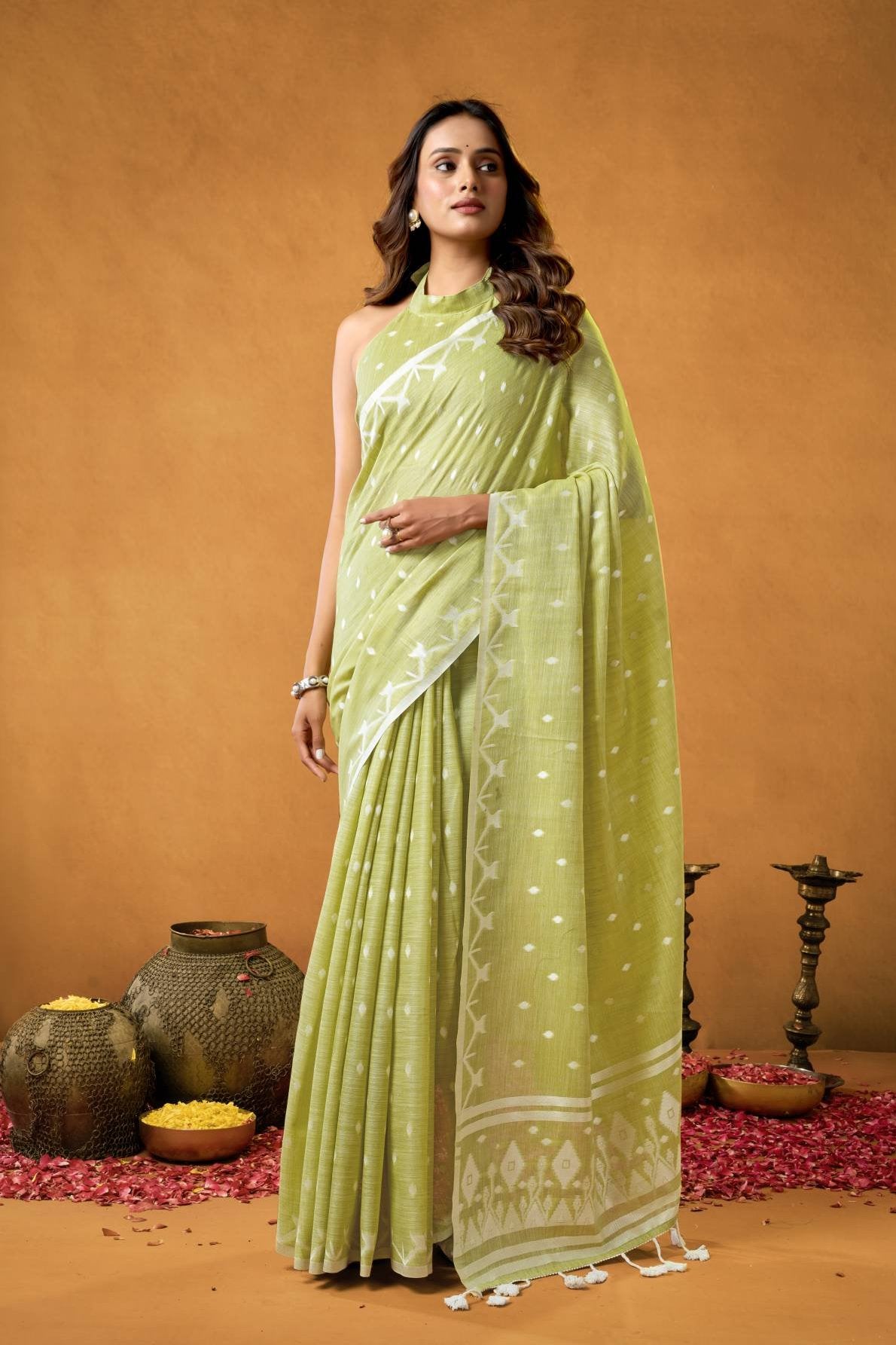A pure linen saree featuring a detailed, traditional Chickankari weave on the border and pallu, paired with a running blouse fabric adorned with all-over weave buttis and a matching border, suitable for elegant occasions.