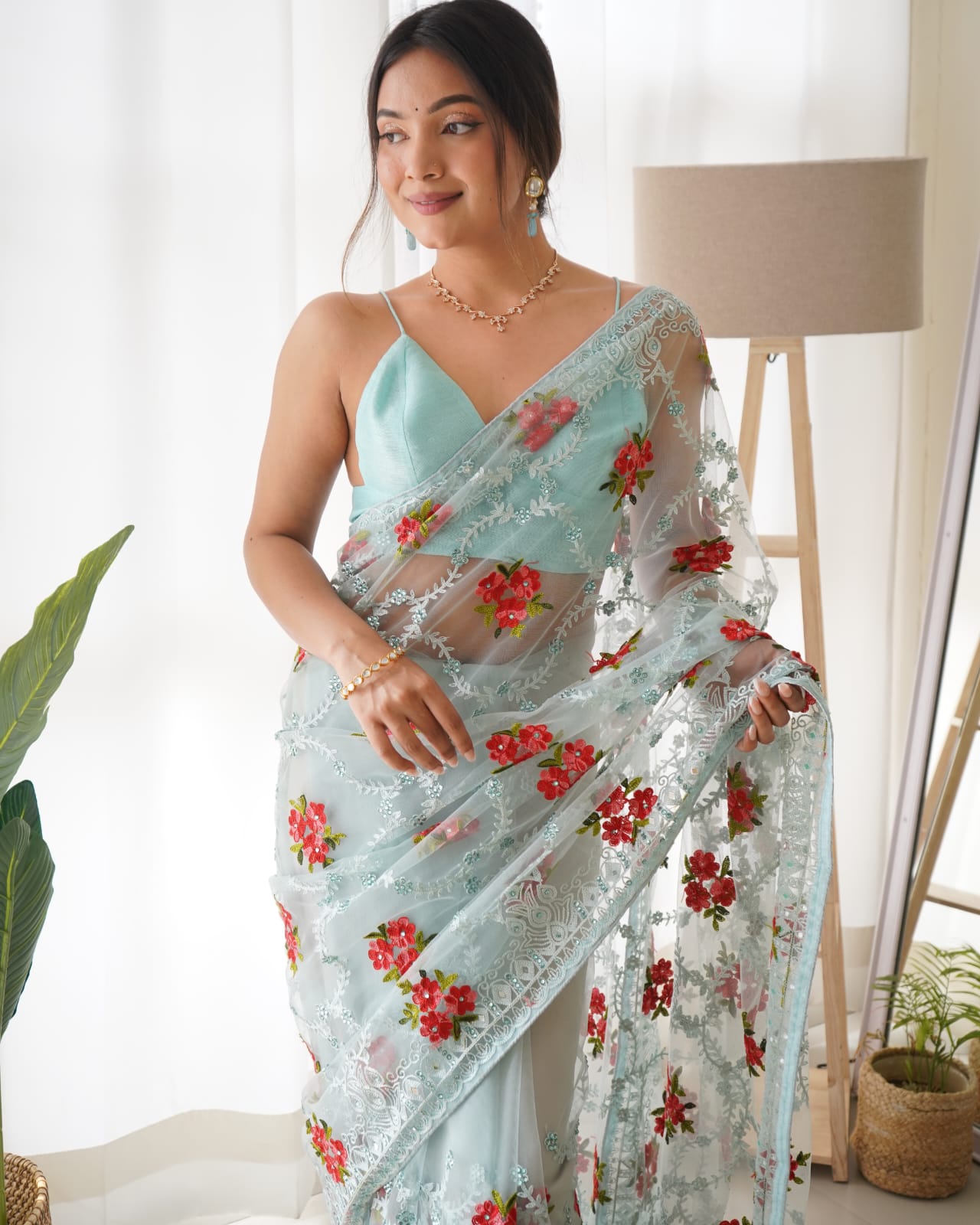 Mustard yellow heavy butterfly net saree with red and green floral aari embroidery and stone work