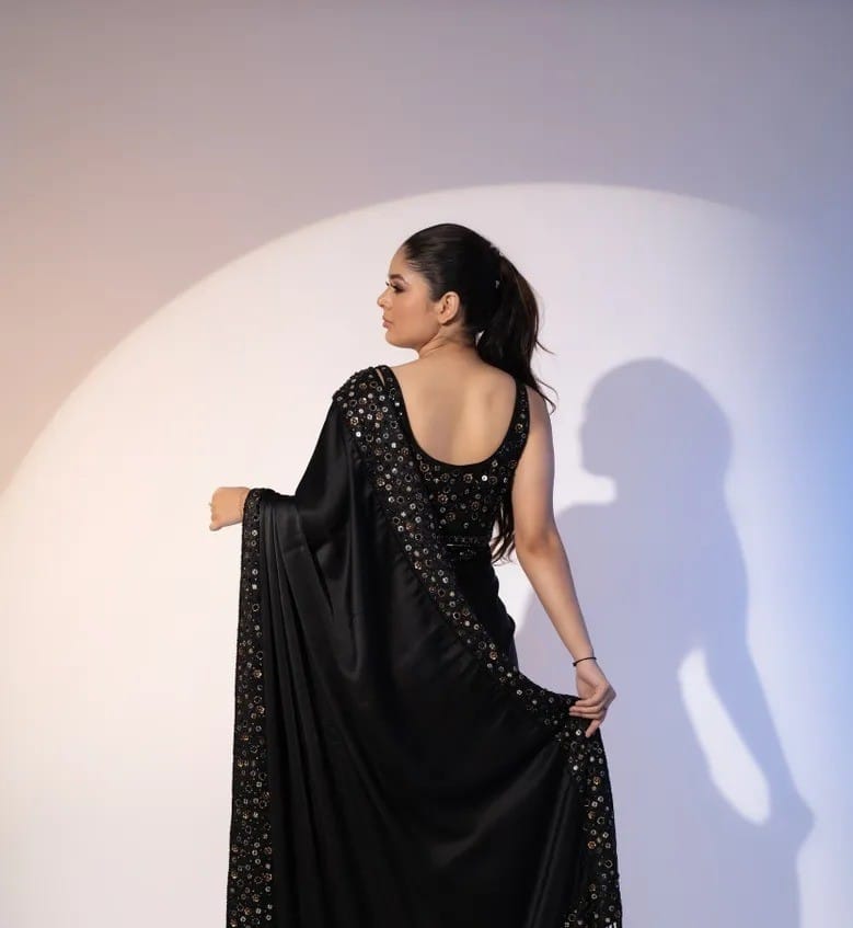 Model wearing elegant black Rangoli silk saree with multi-sequence embroidery border and sleeveless heavy sequin blouse