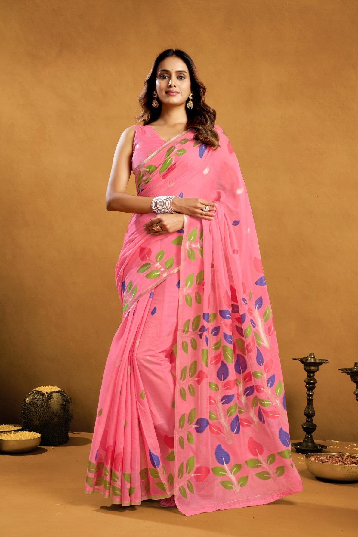 A Pure Cotton Spun Saree featuring exquisite all-over floral Jamdani weaving. The saree is accompanied by a running blouse piece detailed with all-over leaf weave butties and a matching border, available as a six-piece set.