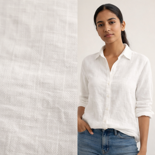 Woman wearing a white shirt and blue jeans standing against a textured white wall.