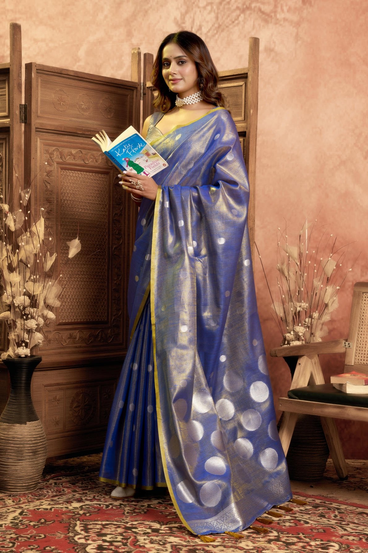 A Pure Tissue Silk Saree defined by its shimmering texture and continuous Pola Weave pattern throughout the body. The design is completed with a richly woven border detail on the pallu and includes a matching All-over Weave Tissue Silk Blouse piece, packaged as a six-piece set.