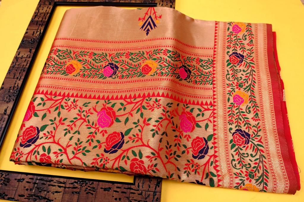 Exquisite Soft Lichi Silk Paithani saree in luminous golden beige, featuring scattered multi-colour floral motifs on the body and a magnificent pallu with vibrant floral tree designs, elegantly draped with a red border.