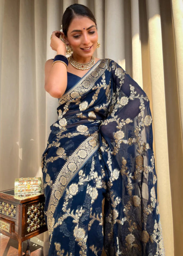 Woman wearing a blue saree with gold embroidery indoors