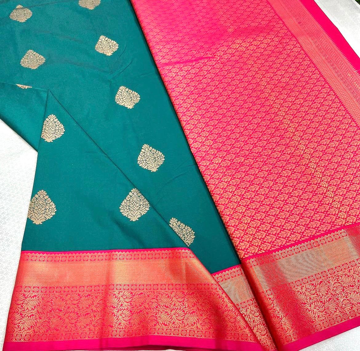 Teal/Peacock Green Banarasi Silk saree with scattered gold zari leaf motifs and a vibrant hot pink and gold zari woven contrast border and pallu, elegantly draped on a white surface.