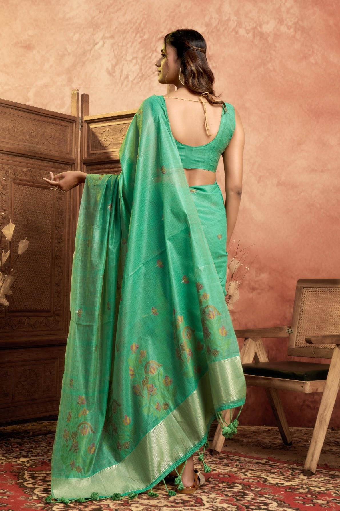 A Pure Cotton Spun Saree featuring delicate, traditional floral Jamdani weaving throughout the body. The pallu is accentuated with an elegant Zari weave border, and it comes with a running blouse piece that includes a matching floral weave border, sold as a six-piece set.
