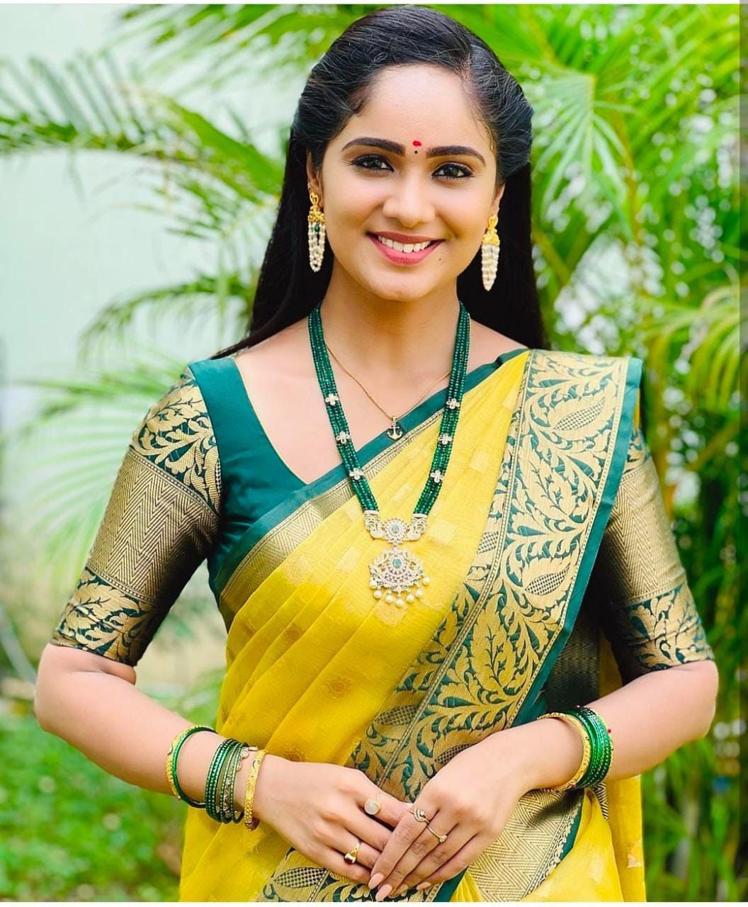 Bright yellow Banarasi Silk saree with wide, deep green and gold zari woven contrast border and pallu, featuring traditional motifs.