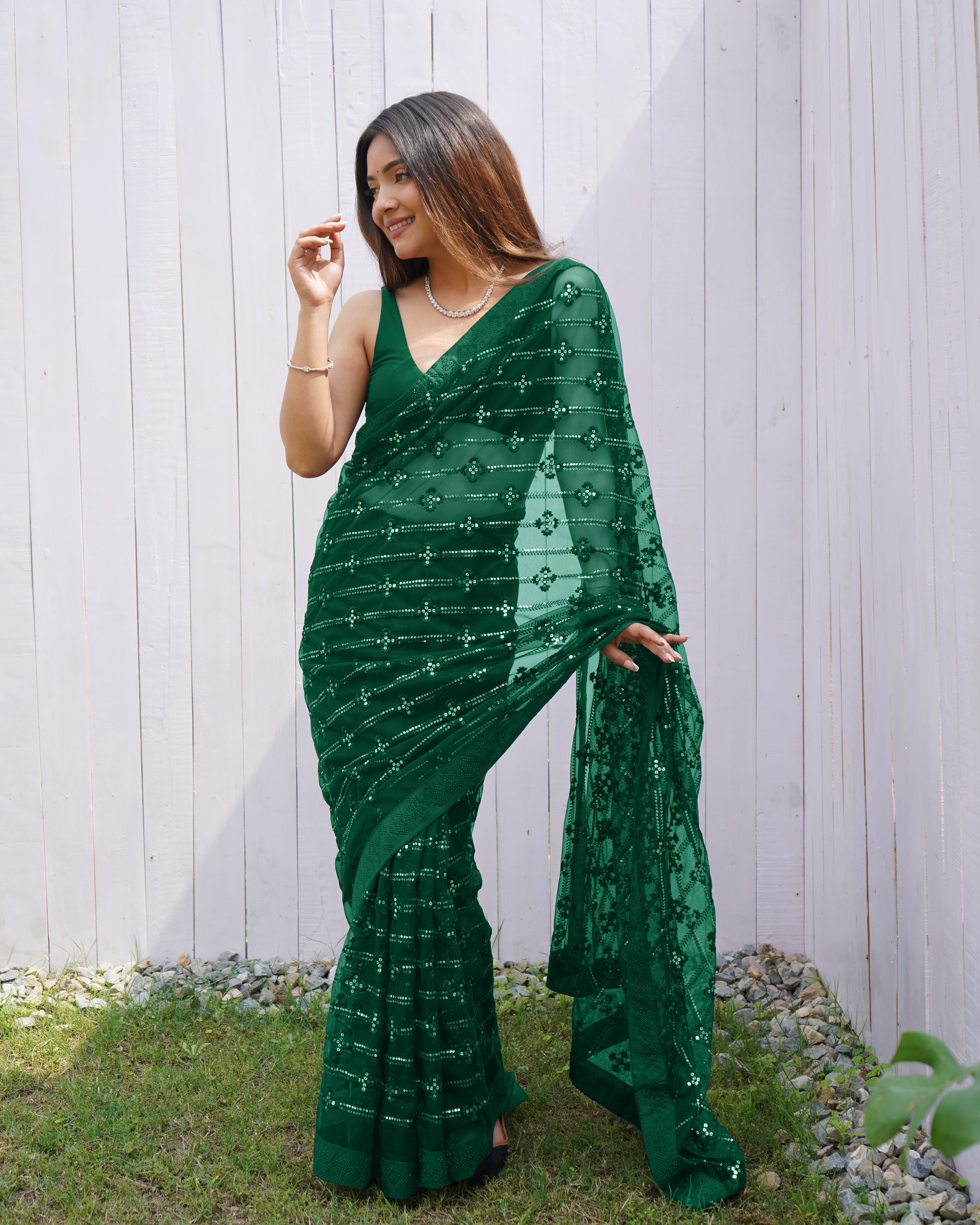 Model wearing a sheer Green butterfly net saree with horizontal sequin lines and multi-thread embroidery details.