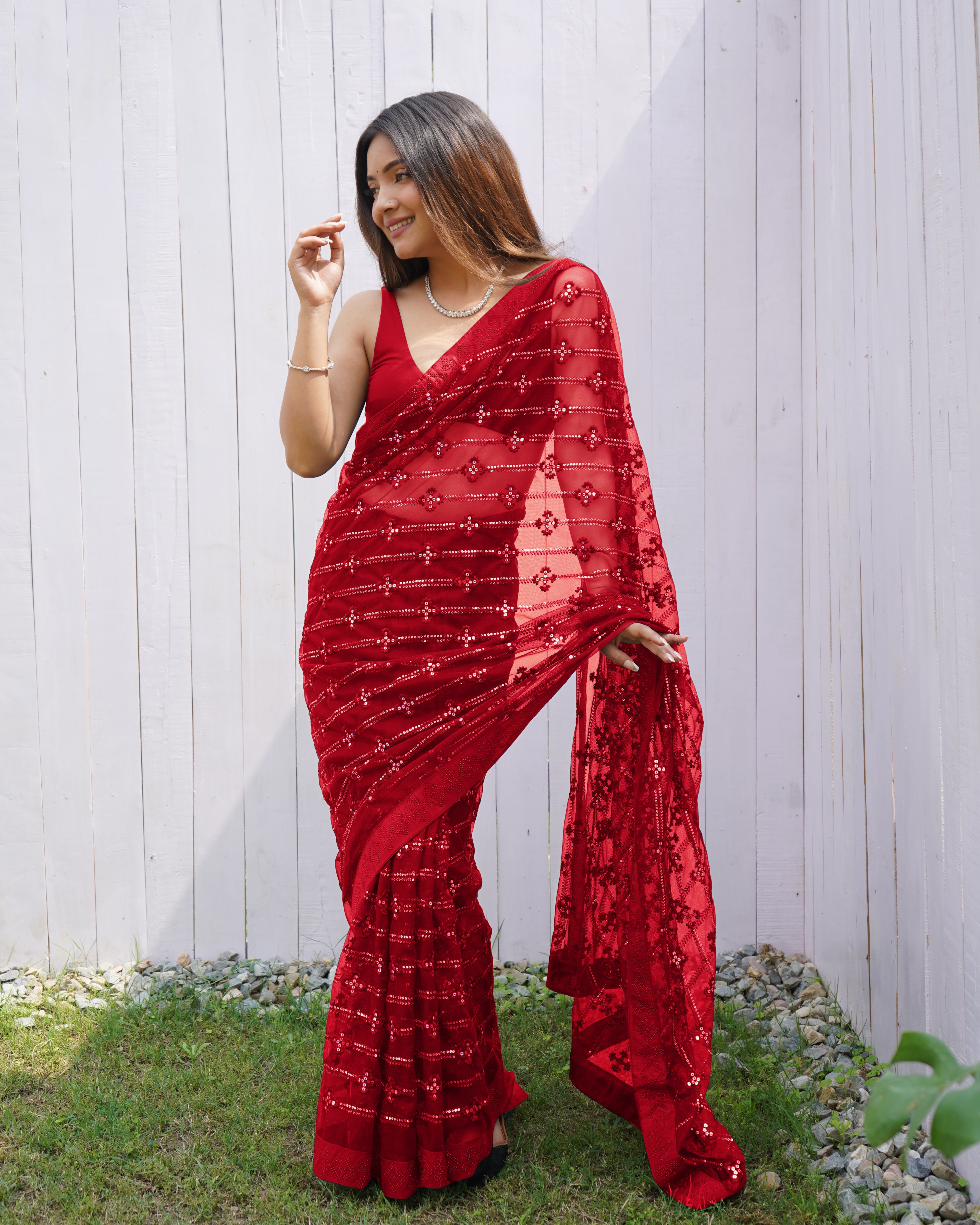 Model wearing a sheer Red butterfly net saree with horizontal sequin lines and multi-thread embroidery details.