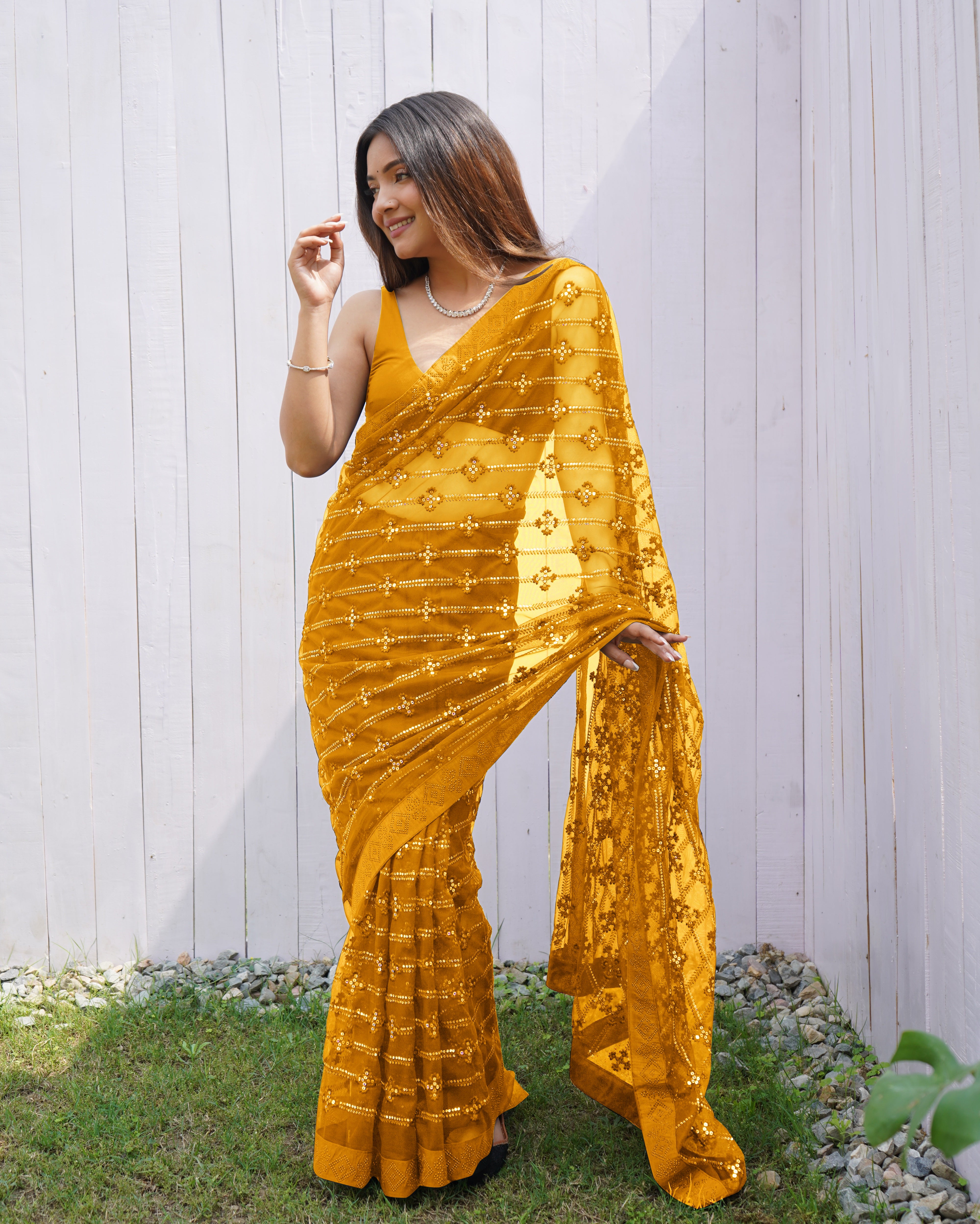 Model wearing a sheer Yellow butterfly net saree with horizontal sequin lines and multi-thread embroidery details.