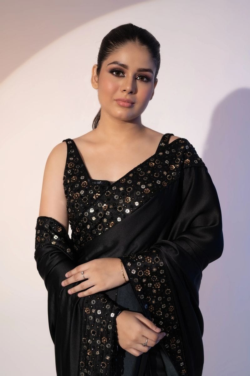 Model wearing elegant black Rangoli silk saree with multi-sequence embroidery border and sleeveless heavy sequin blouse