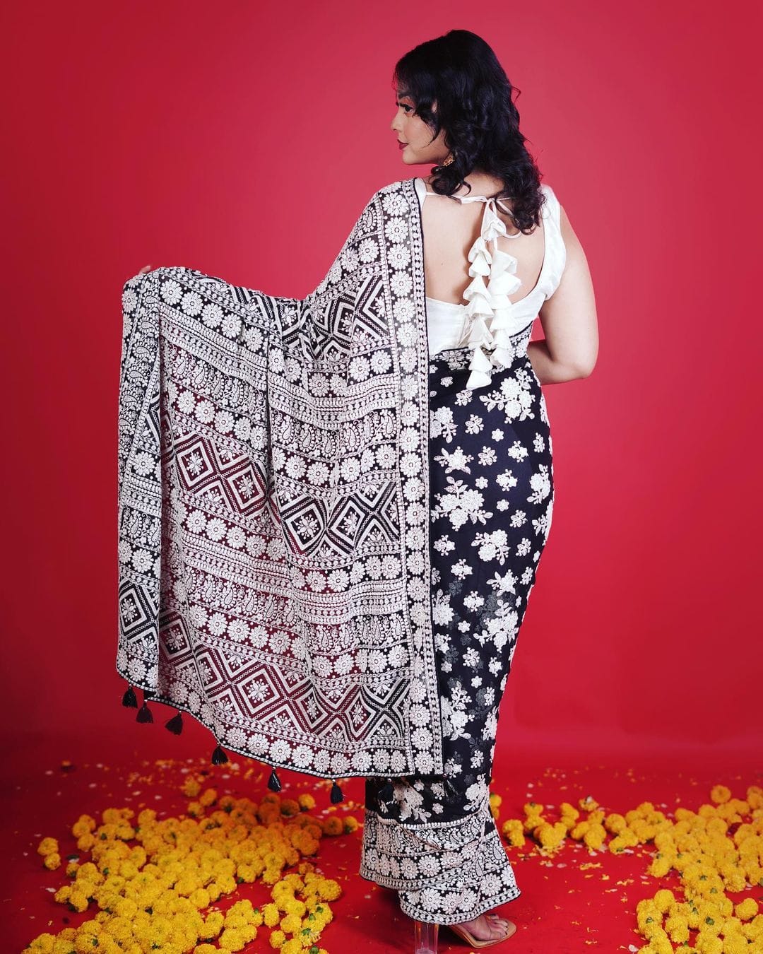 Model wearing black Fox Georgette saree with heavy white Lakhnowi thread embroidery and white silk blouse