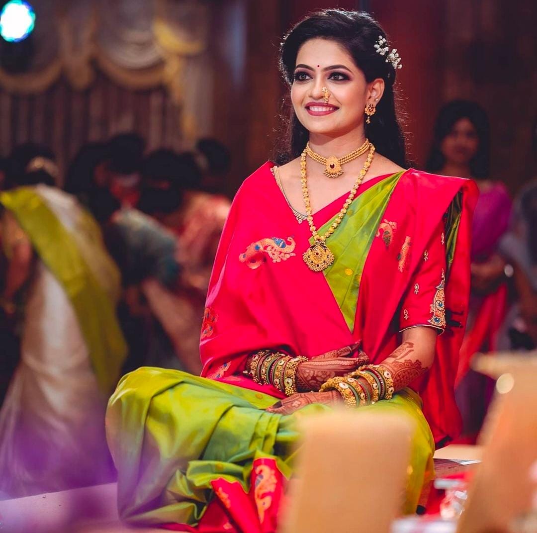 Radiant Soft Lichi Silk saree in lime green with subtle self-weaves, featuring a vibrant fuchsia pink pallu and border with intricate gold zari motifs, worn by a smiling woman on a balcony