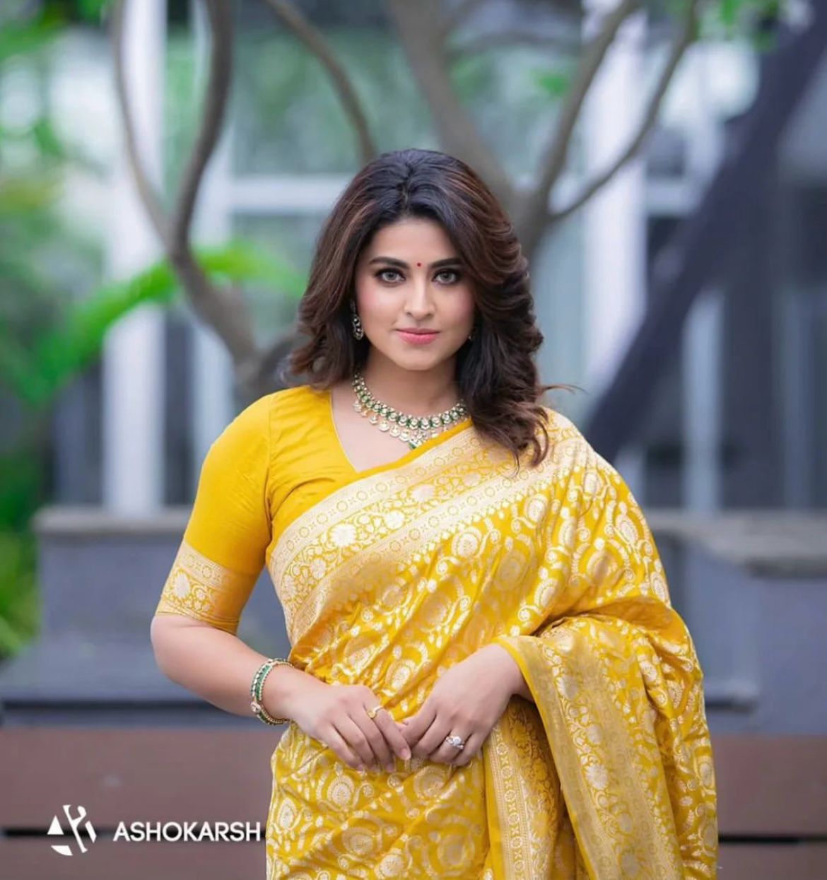 Woman wearing a yellow saree with a blurred background