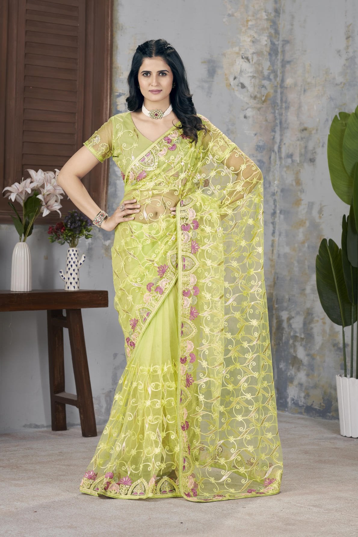 Model wearing Firozi heavy butterfly net saree with Aari Dori and foil thread embroidery suitable for weddings