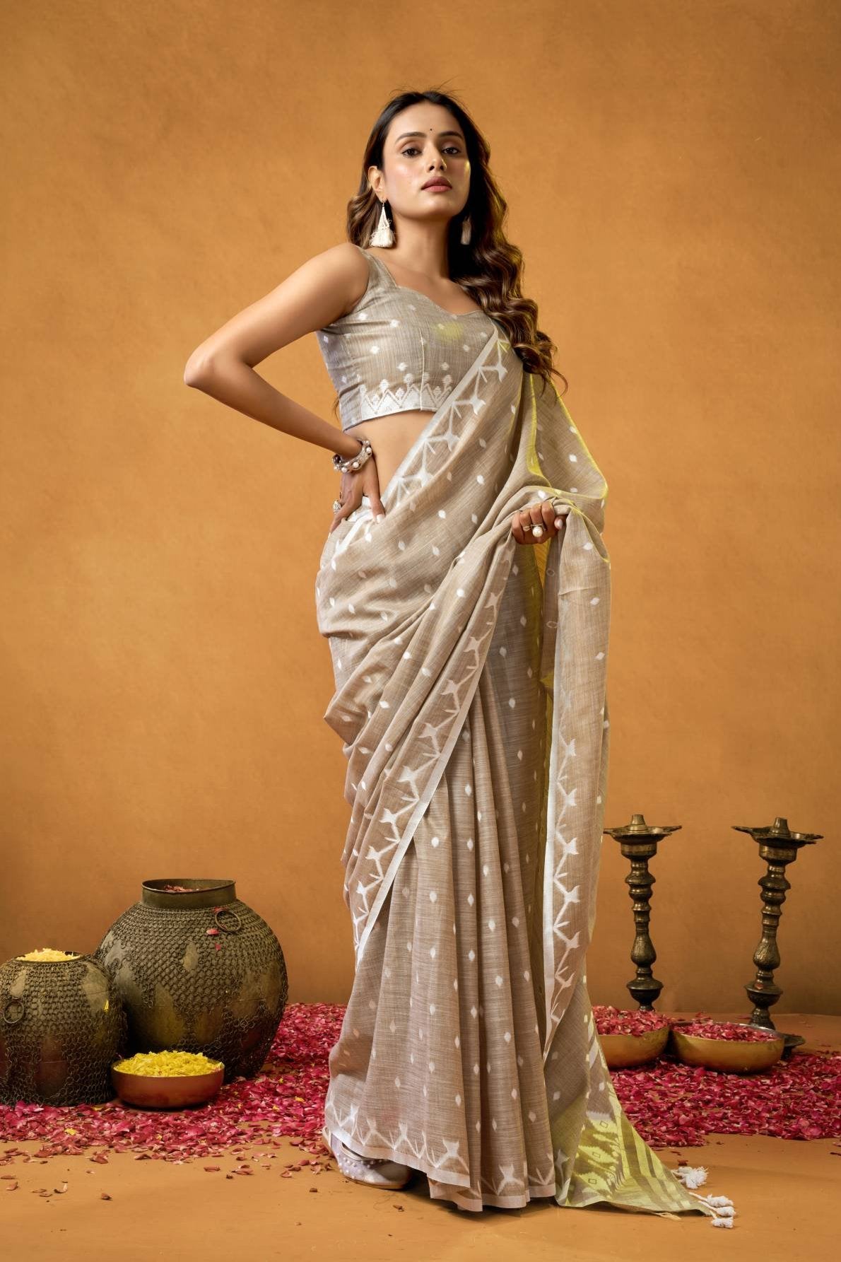 A pure linen saree featuring a detailed, traditional Chickankari weave on the border and pallu, paired with a running blouse fabric adorned with all-over weave buttis and a matching border, suitable for elegant occasions.