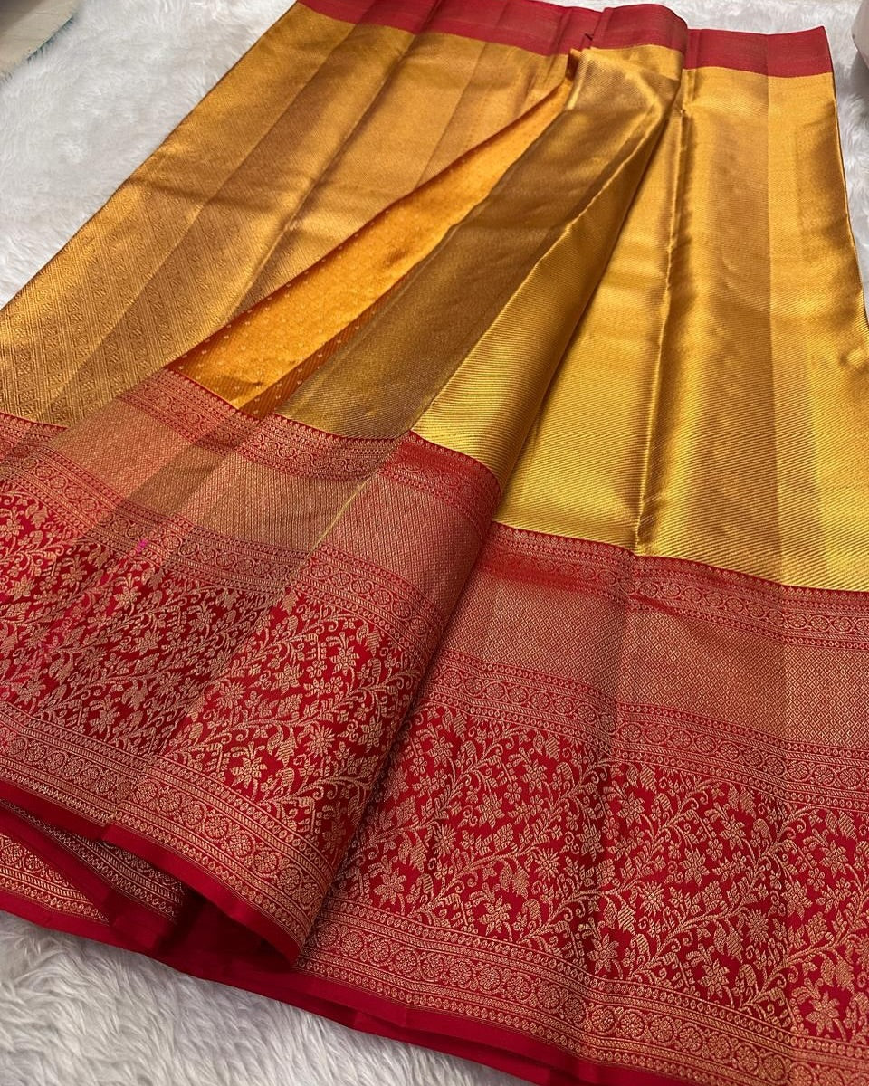 Radiant gold Banarasi Silk saree with a shimmering self-weave pattern, featuring a bold classic red border and pallu intricately woven with dense gold zari floral and ornamental motifs, elegantly draped.