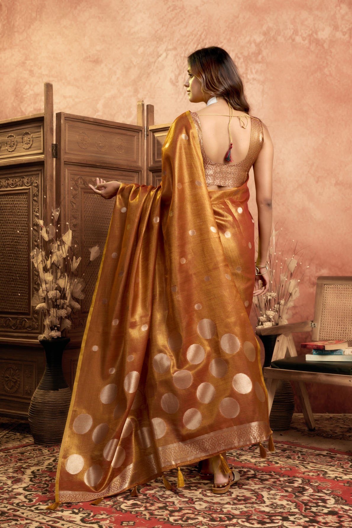 A Pure Tissue Silk Saree defined by its shimmering texture and continuous Pola Weave pattern throughout the body. The design is completed with a richly woven border detail on the pallu and includes a matching All-over Weave Tissue Silk Blouse piece, packaged as a six-piece set.