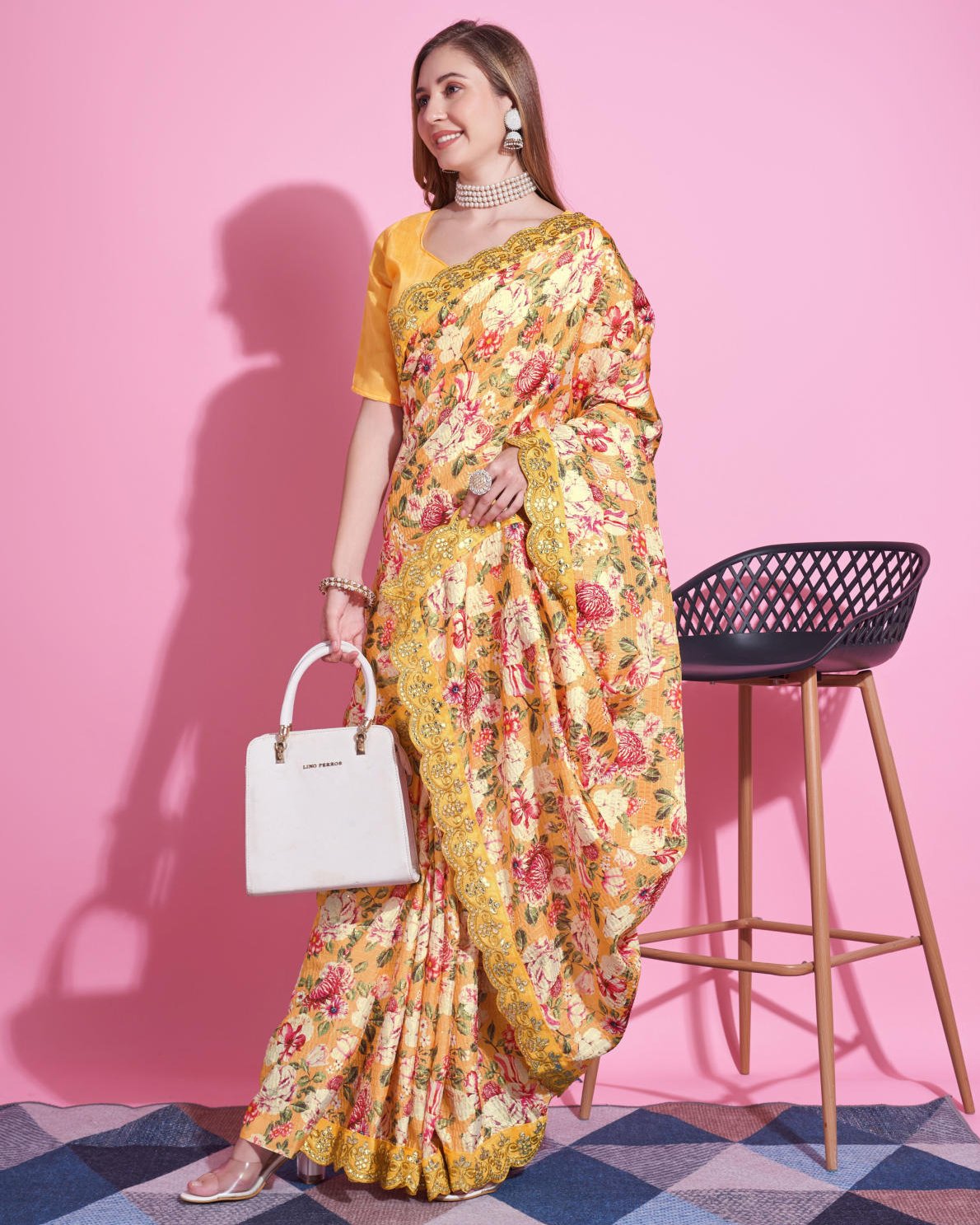 Yellow Vichitra Silk Saree with floral digital print and Zari Dori embroidered border worn by model holding white handbag