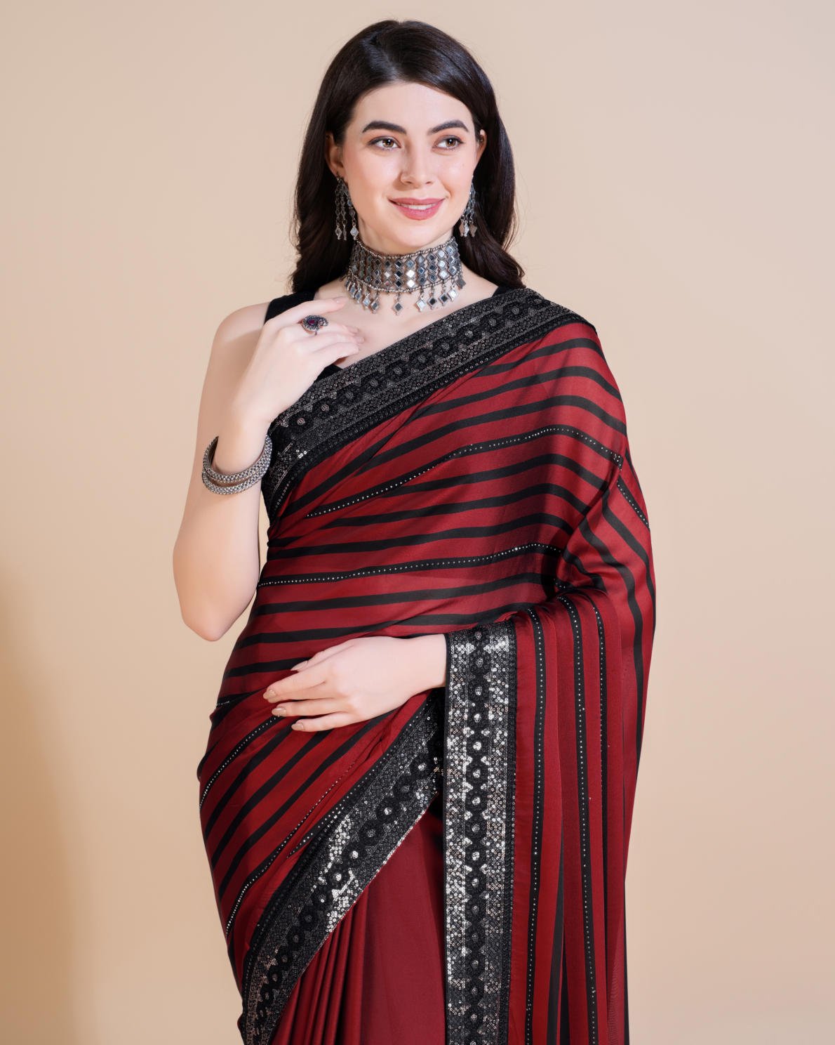 Model wearing Rangoli Silk Leheriya saree with black stripes, hotfix work, and sequin embroidered border
