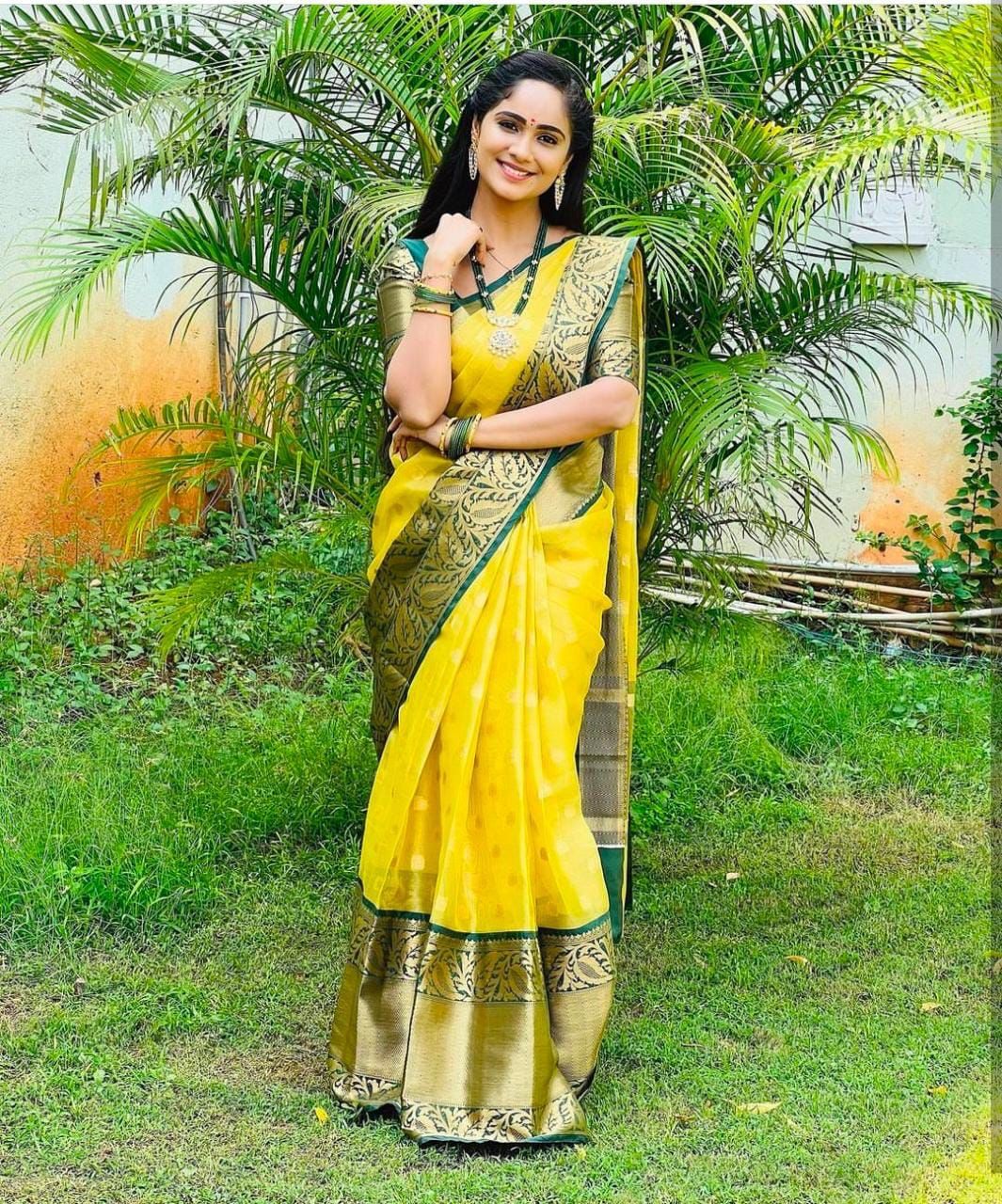Bright yellow Banarasi Silk saree with wide, deep green and gold zari woven contrast border and pallu, featuring traditional motifs.