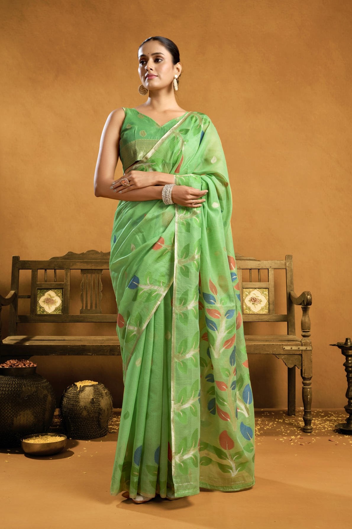 A Pure Cotton Spun Saree featuring exquisite all-over floral Jamdani weaving. The saree is accompanied by a running blouse piece detailed with all-over leaf weave butties and a matching border, available as a six-piece set.