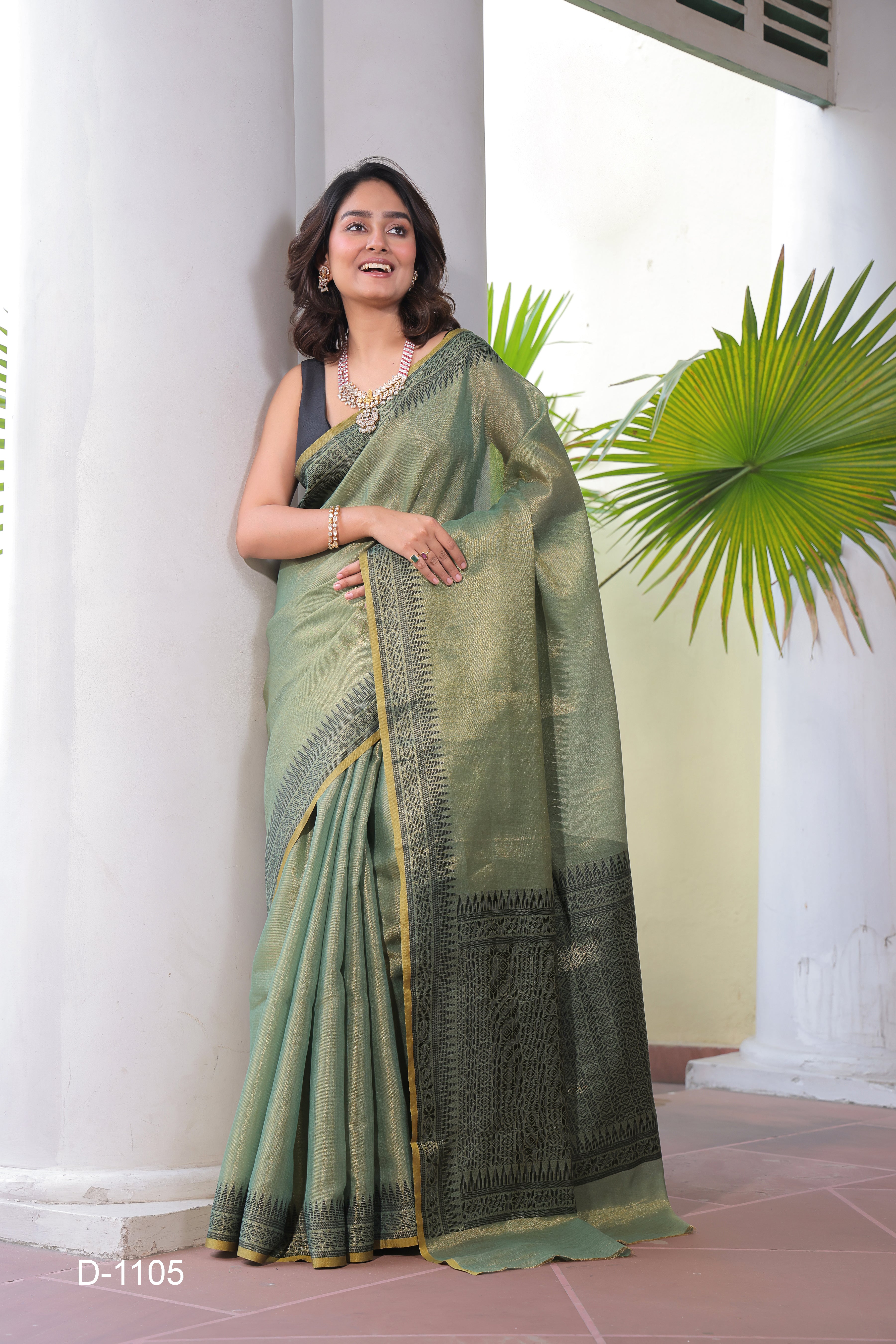 A lightweight Linen Tissue Silk Saree featuring a beautiful, delicate woven border and a rich Handloom-style pallu. The ensemble includes a matching blouse piece adorned with all-over weave butti patterns, sold as an eight-piece set.