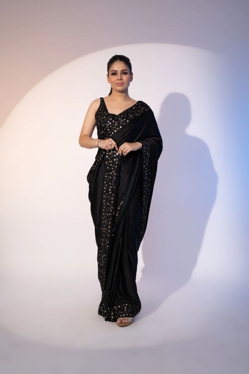 Model wearing elegant black Rangoli silk saree with multi-sequence embroidery border and sleeveless heavy sequin blouse
