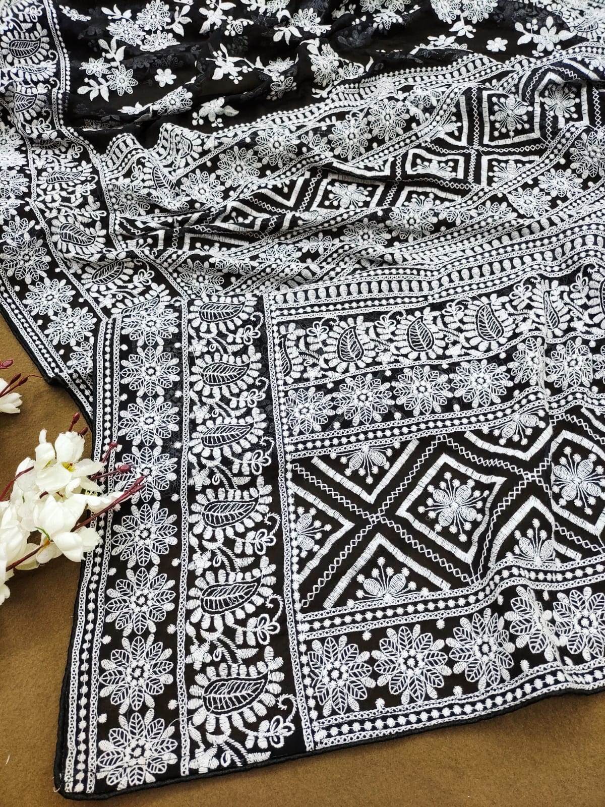 Model wearing black Fox Georgette saree with heavy white Lakhnowi thread embroidery and white silk blouse