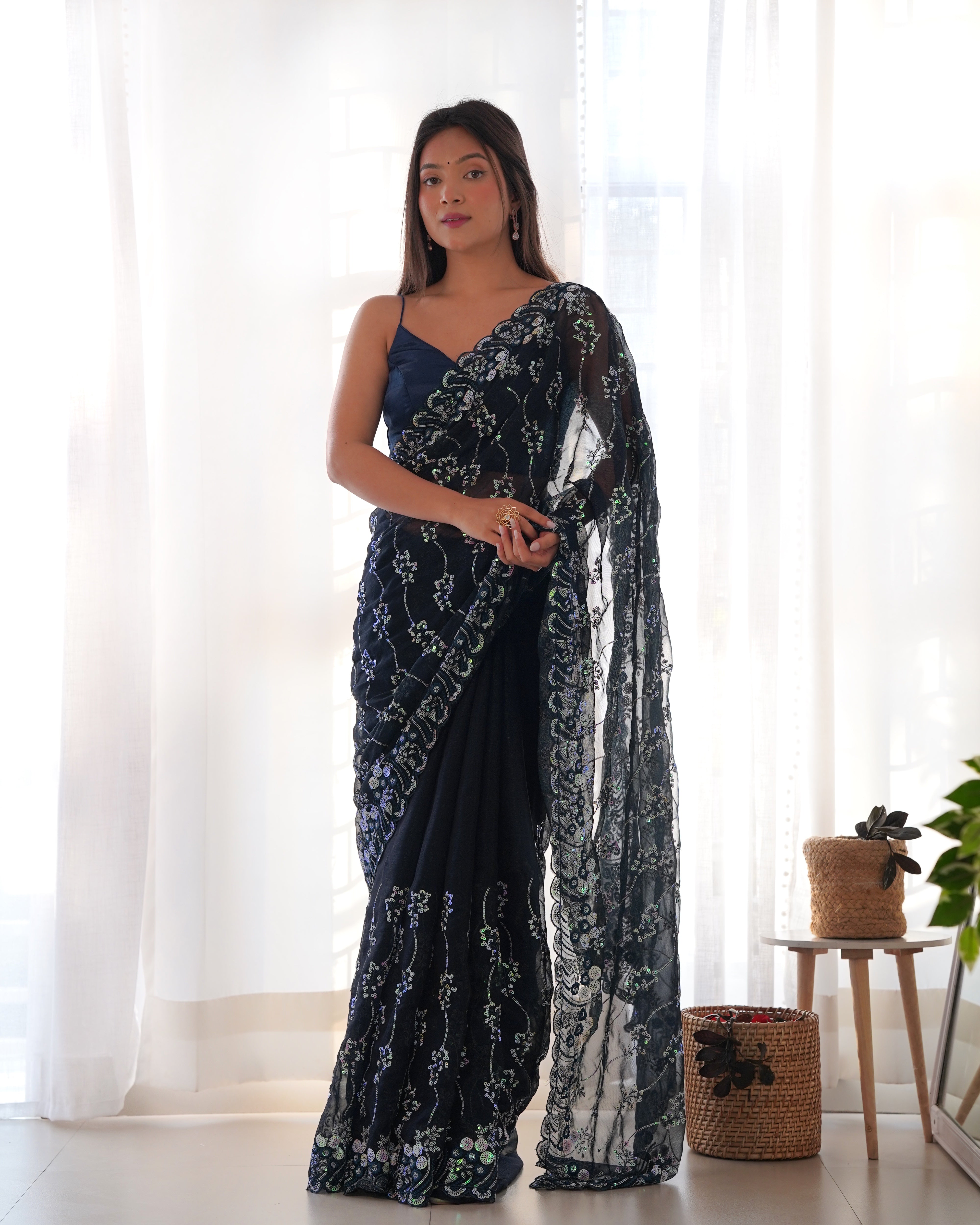 Model wearing a dark shimmer blooming saree with heavy 3mm and 5mm sequin embroidery and scalloped borders