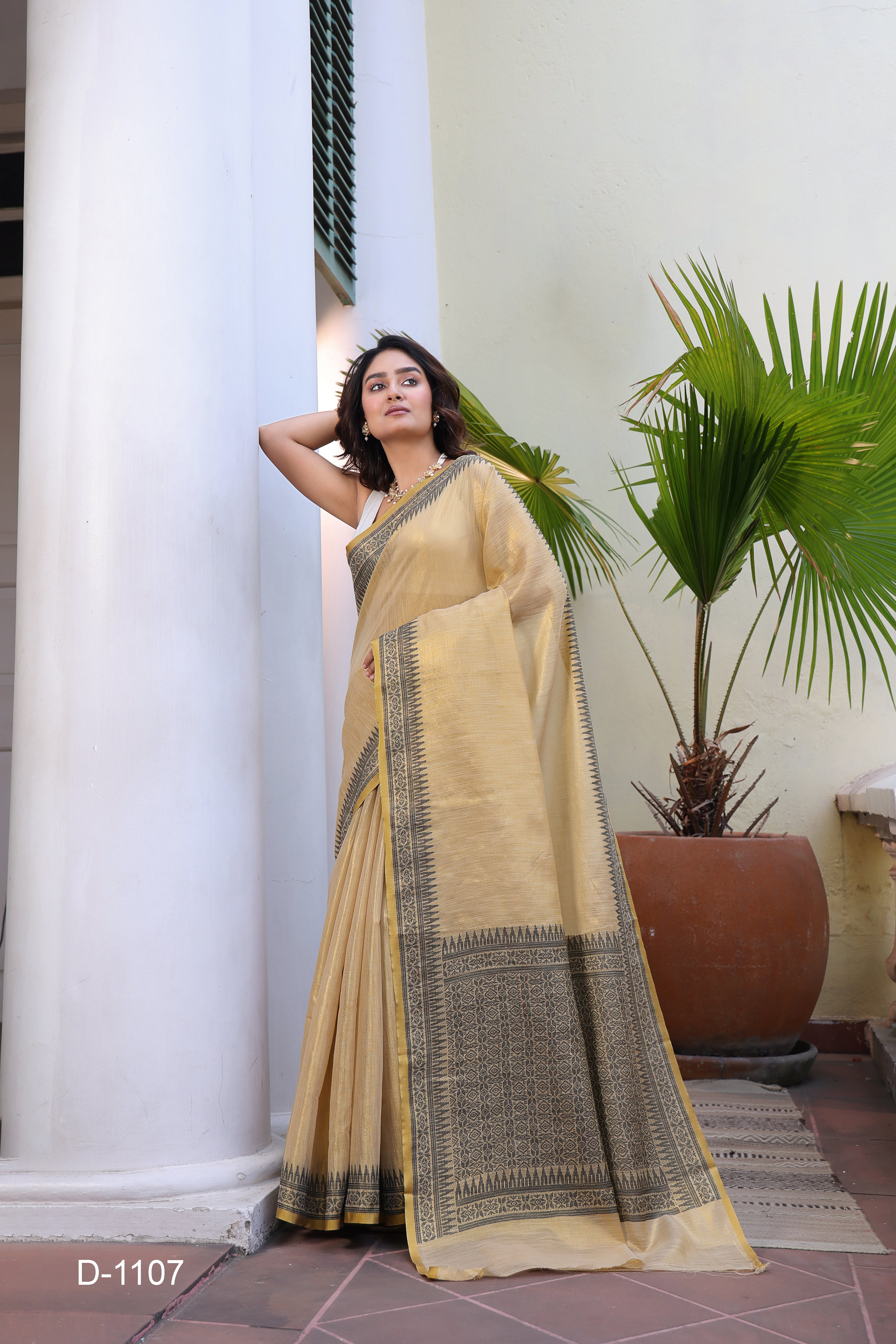 A lightweight Linen Tissue Silk Saree featuring a beautiful, delicate woven border and a rich Handloom-style pallu. The ensemble includes a matching blouse piece adorned with all-over weave butti patterns, sold as an eight-piece set.