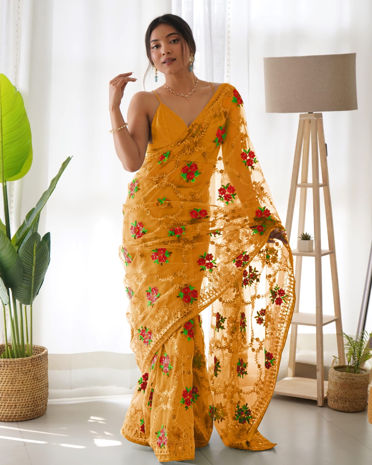 Mustard yellow heavy butterfly net saree with red and green floral aari embroidery and stone work