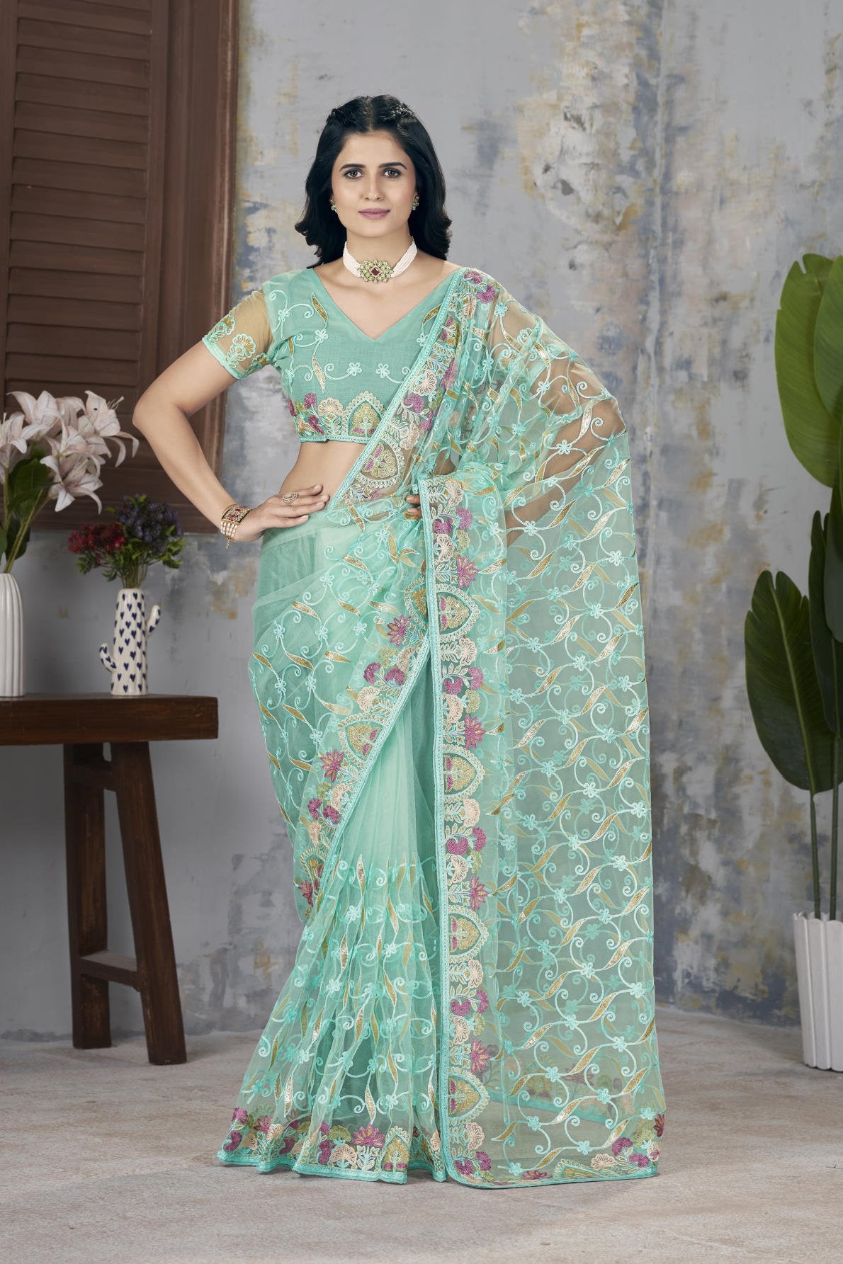 Model wearing Firozi heavy butterfly net saree with Aari Dori and foil thread embroidery suitable for weddings