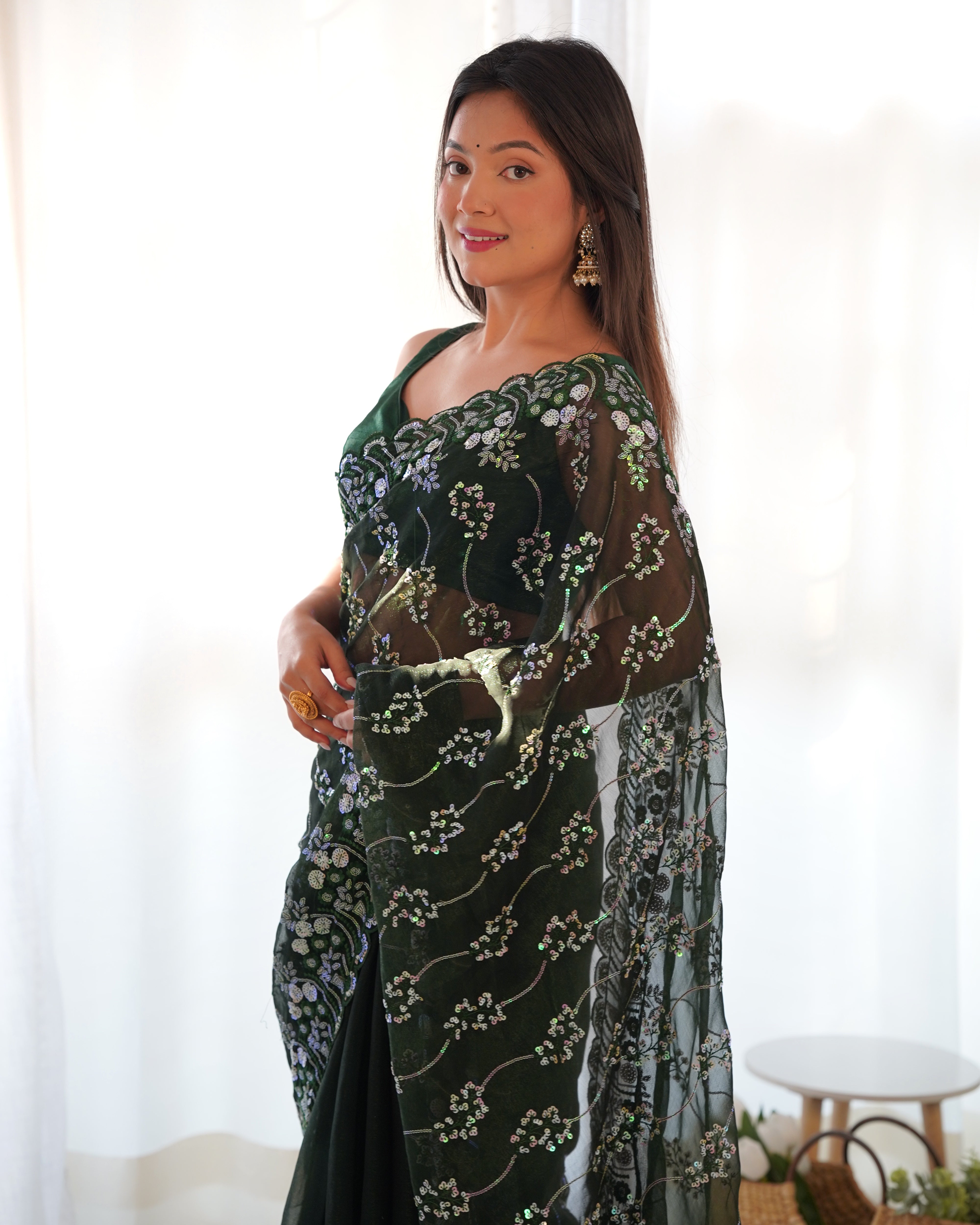 Model wearing a dark shimmer blooming saree with heavy 3mm and 5mm sequin embroidery and scalloped borders