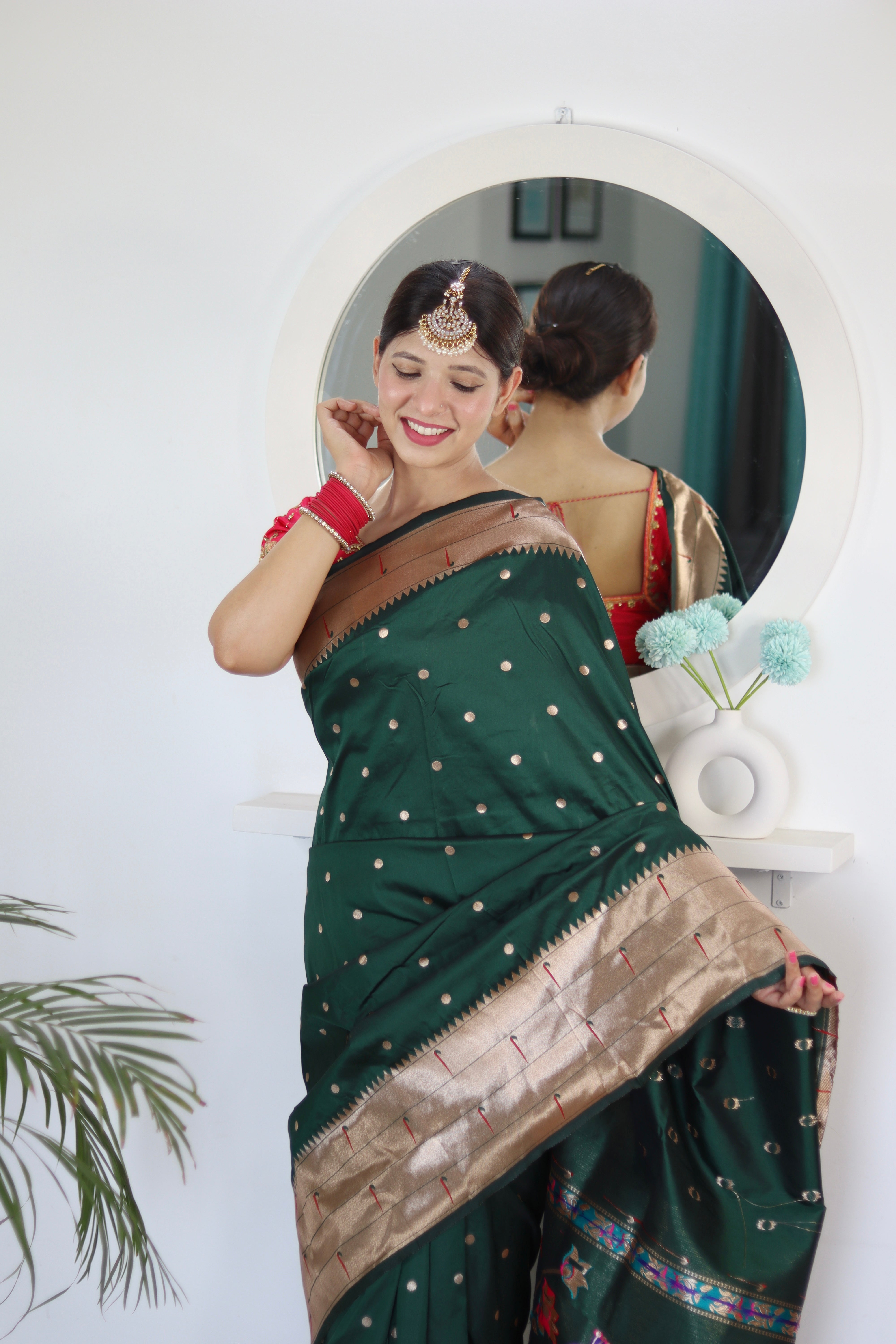 Model wearing Bottle Green Soft Kanjivaram Paithani Silk Saree with Meenakari Zari weaving and rich swan border