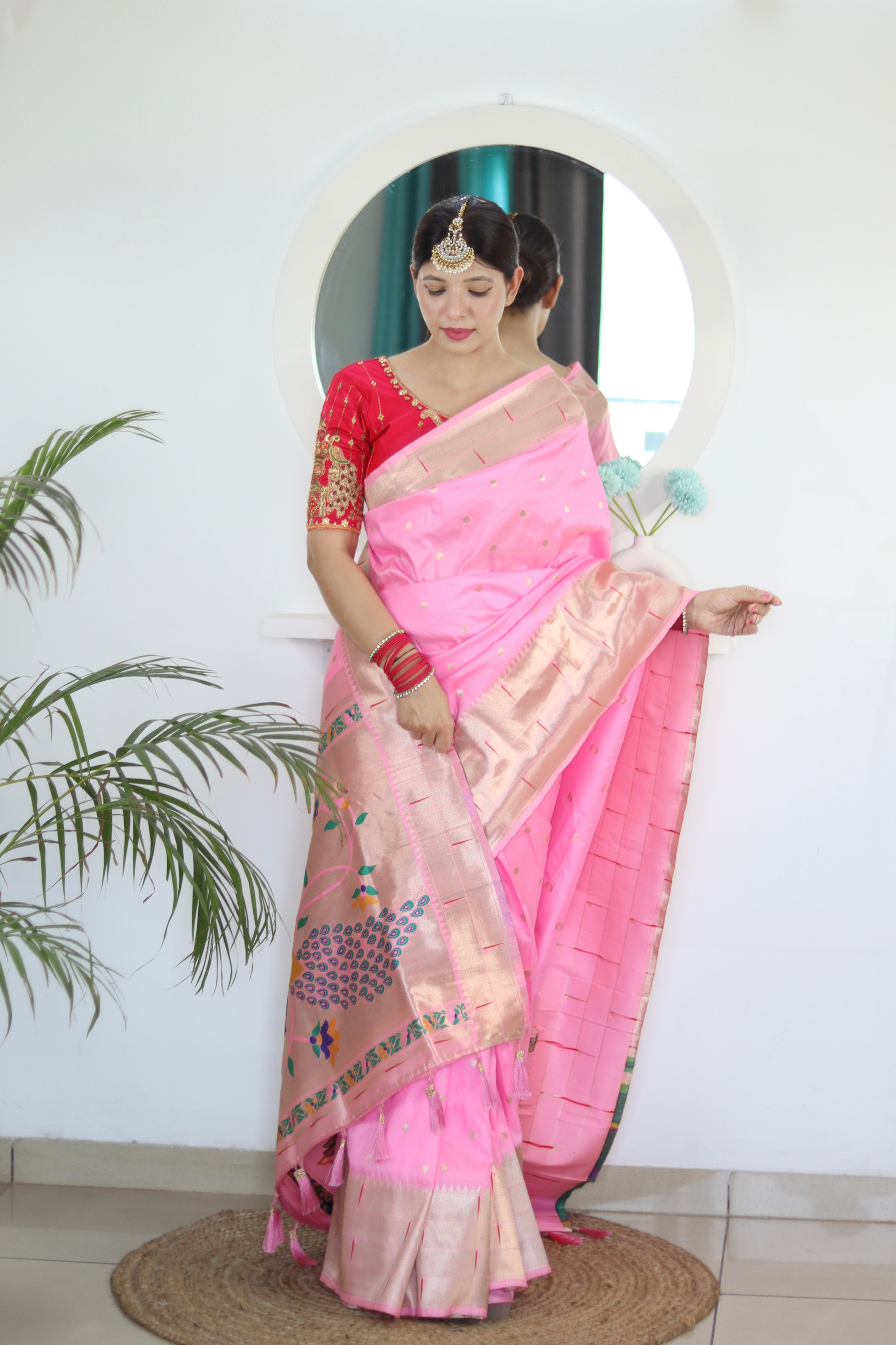 Model wearing Baby Pink Soft Kanjivaram Paithani Silk Saree with Meenakari Zari weaving and rich swan border