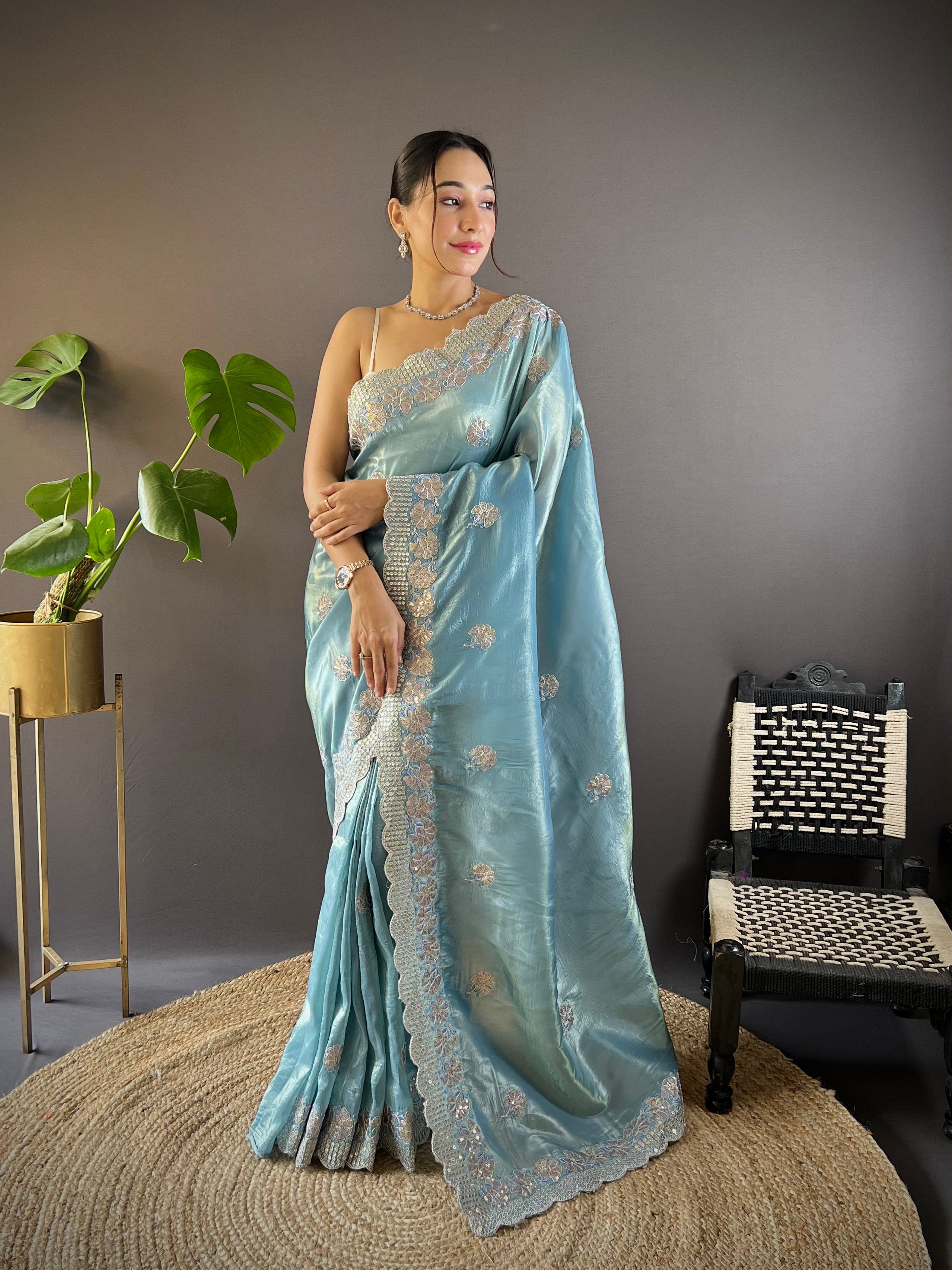 Model wearing shimmering teal blue Gold Crunchy saree with floral sequence embroidery and cutwork border