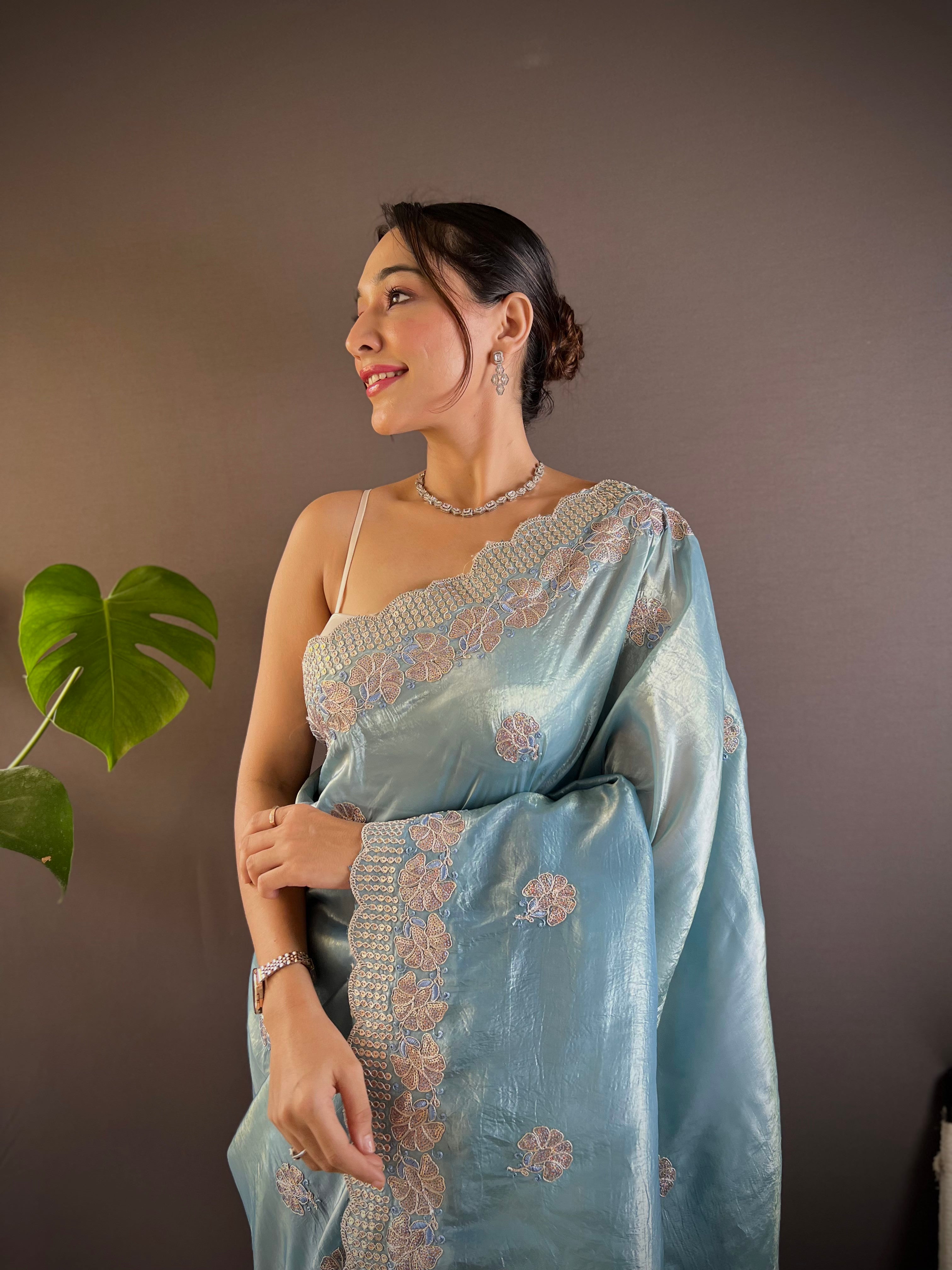 Model wearing shimmering teal blue Gold Crunchy saree with floral sequence embroidery and cutwork border