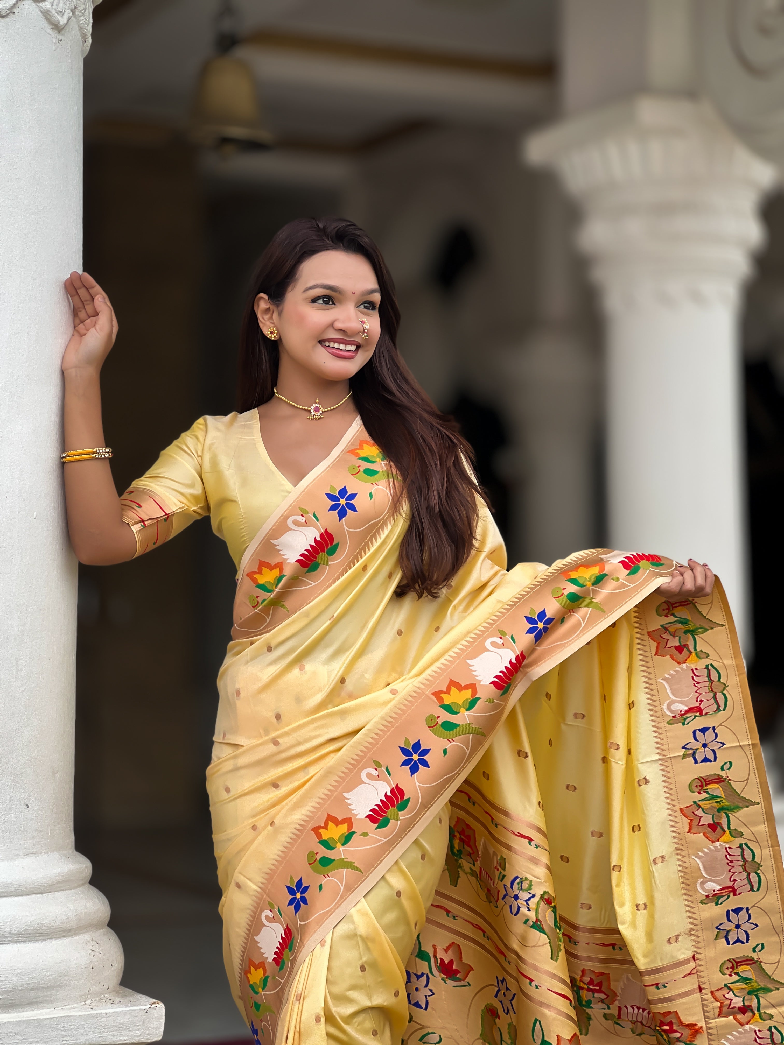 Model wearing Cream soft paithani silk saree with colorful meenakari floral border and gold zari pallu