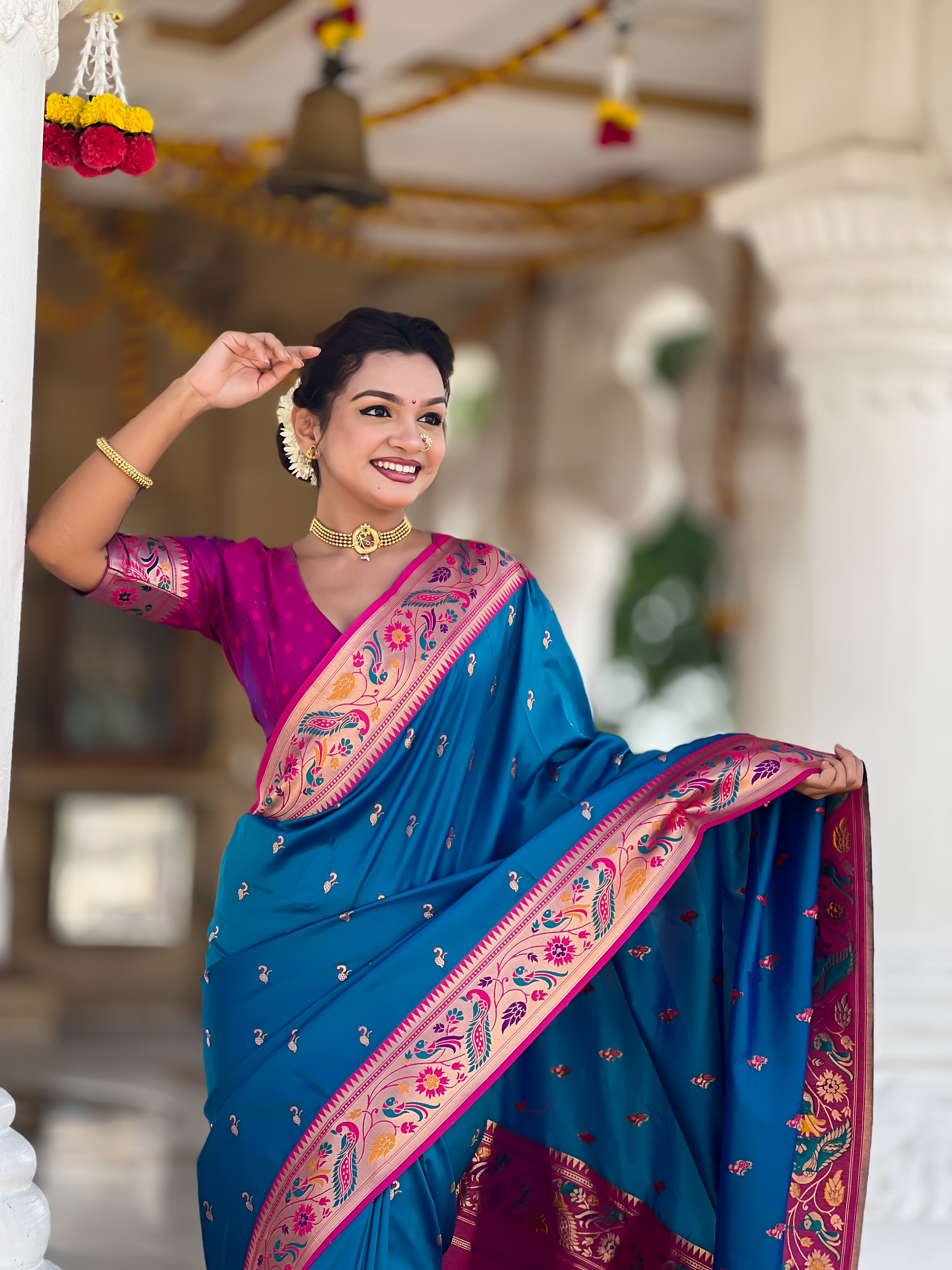 Woman wearing Firozi blue Soft Paithani Silk Saree with pink border and Meenakari Zari weaving motifs