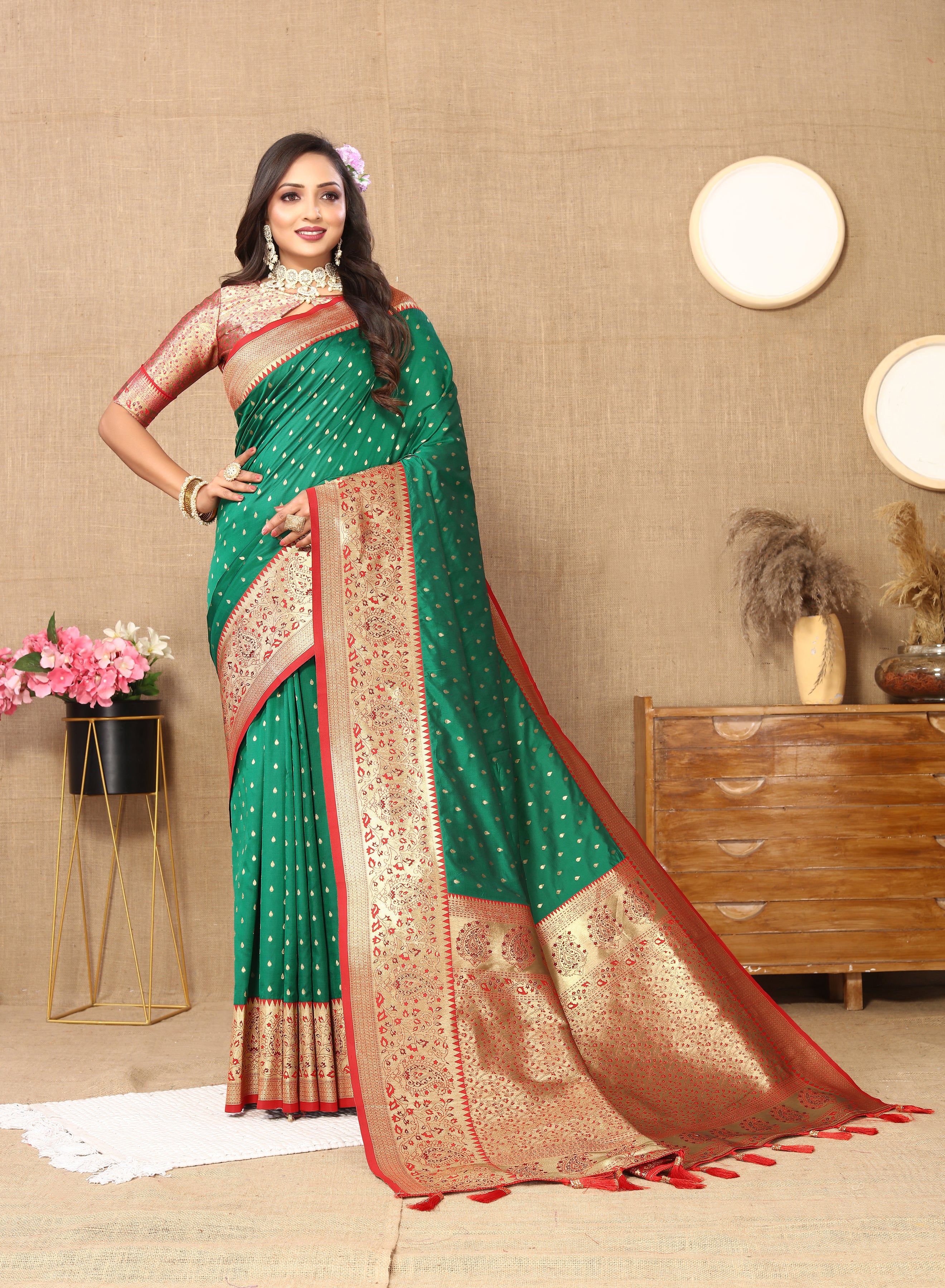 Woman wearing Green soft silk saree with pink contrast border, gold zari motifs, and rich pallu design